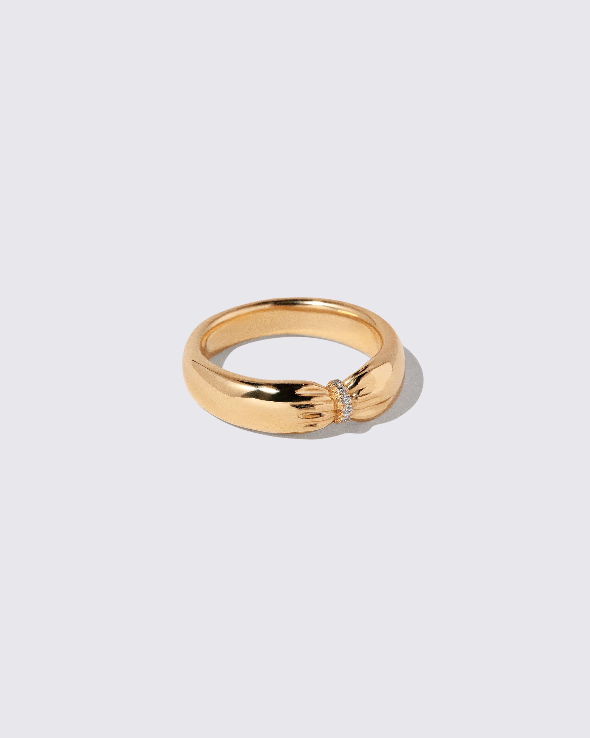 View from the side of the Gold Pavé Pinch Band on light color background.
