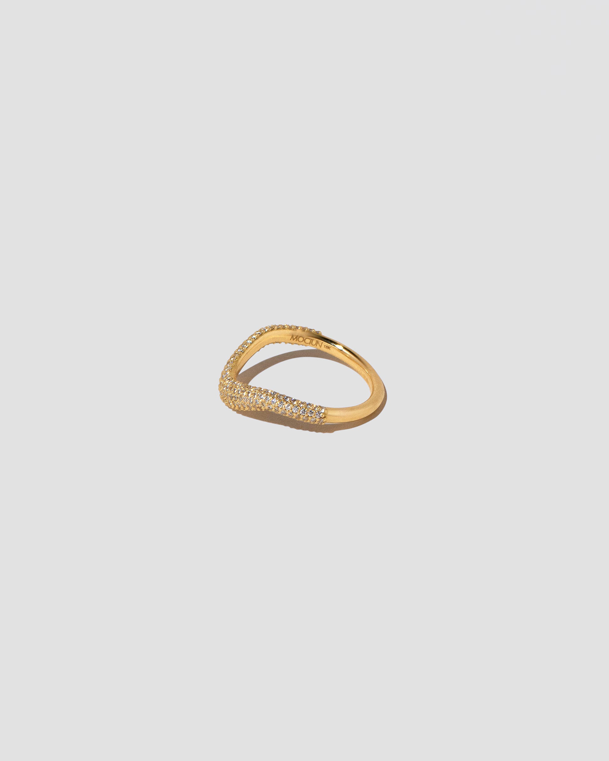 View from the side of the Gold Pavé Thin Level Band on light color background.