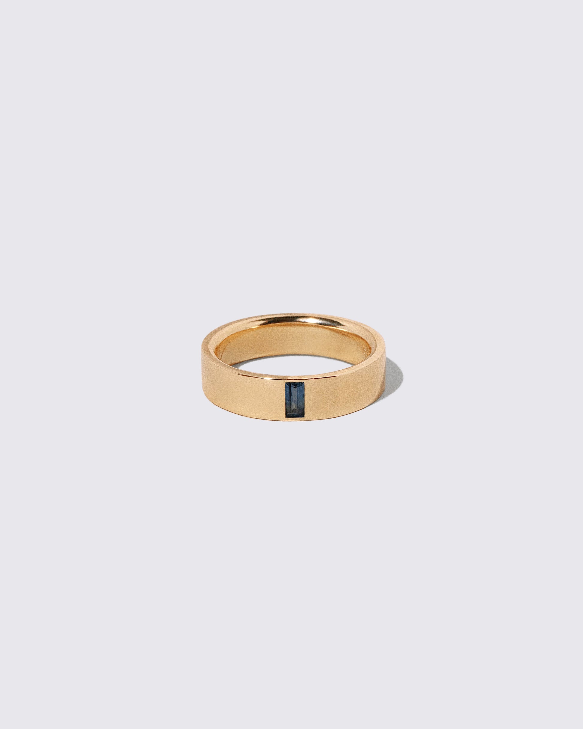 Gold Australian Bicolor Sapphire North South 5mm Baguette-Set Piet Band on light color background.