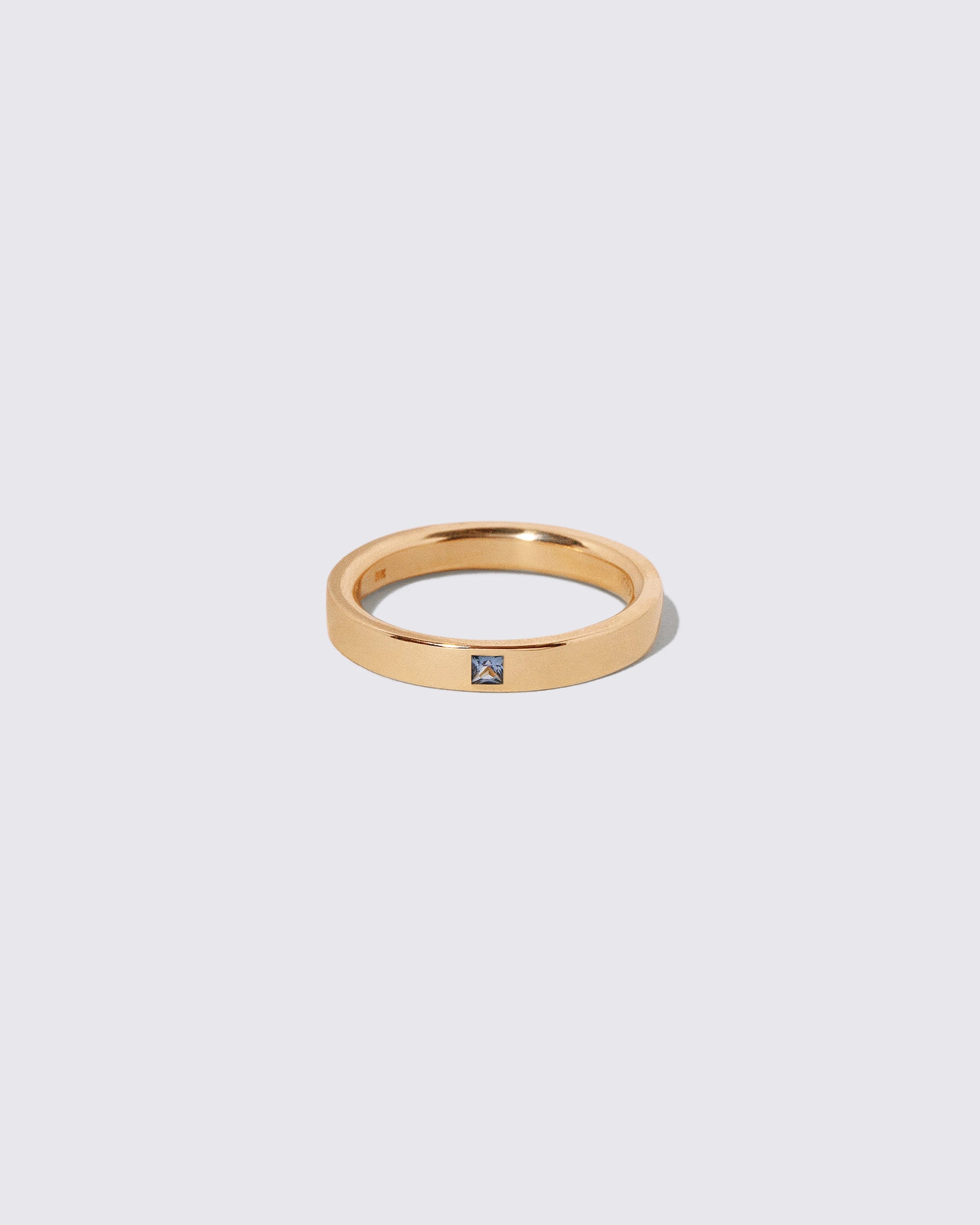 Gold Yogo Mine Cornflower Blue Sapphire 3mm Square Cut Piet Band on light color background.