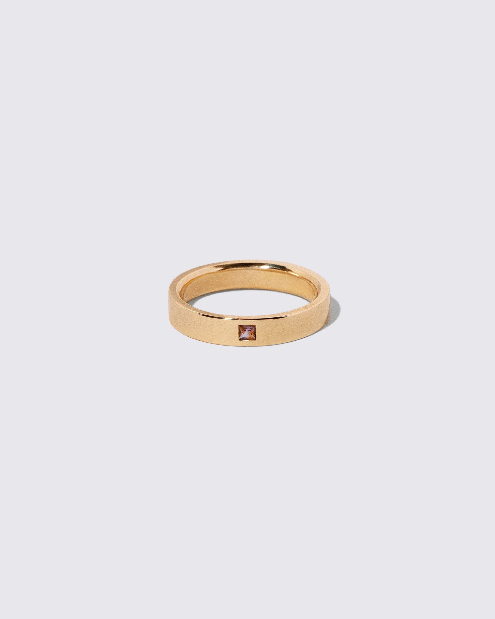 Gold Sri Lankan Bicolor Sapphire 4mm Square Cut Piet Band on light color background.