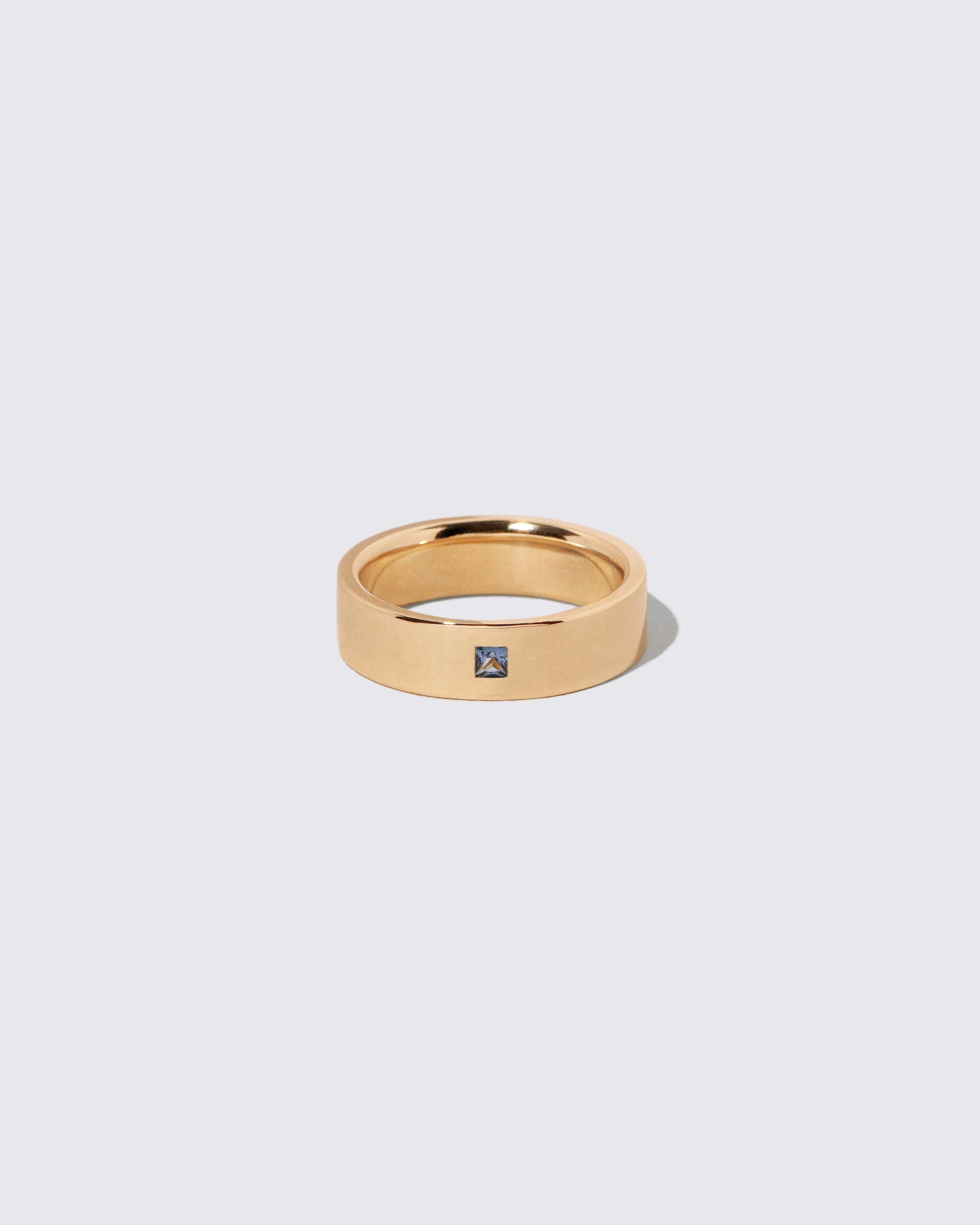 Gold Yogo Mine Cornflower Blue Sapphire 6mm Square Cut Piet Band on light color background.