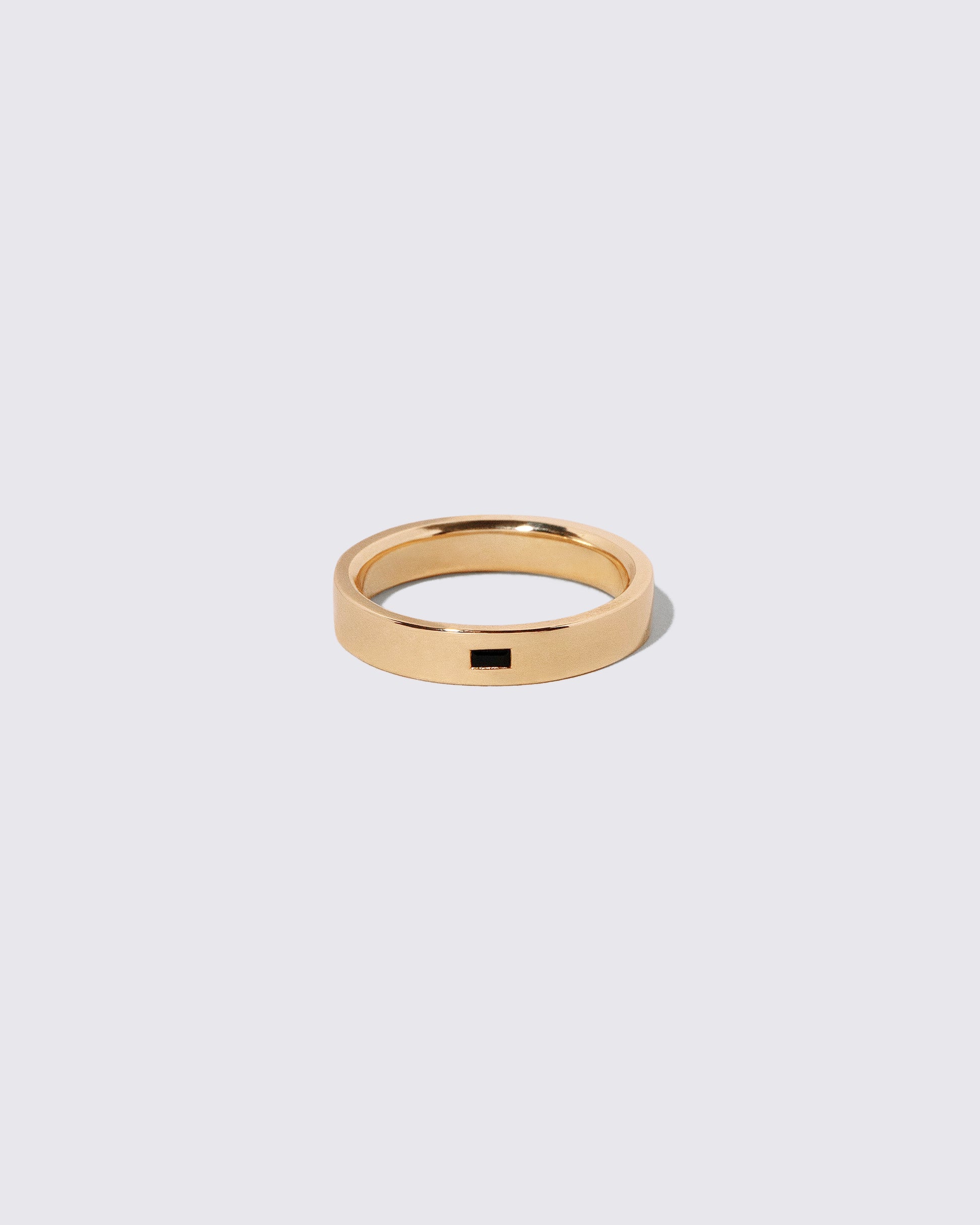 Gold Black Spinel East West 4mm Baguette-Set Piet Band on light color background.
