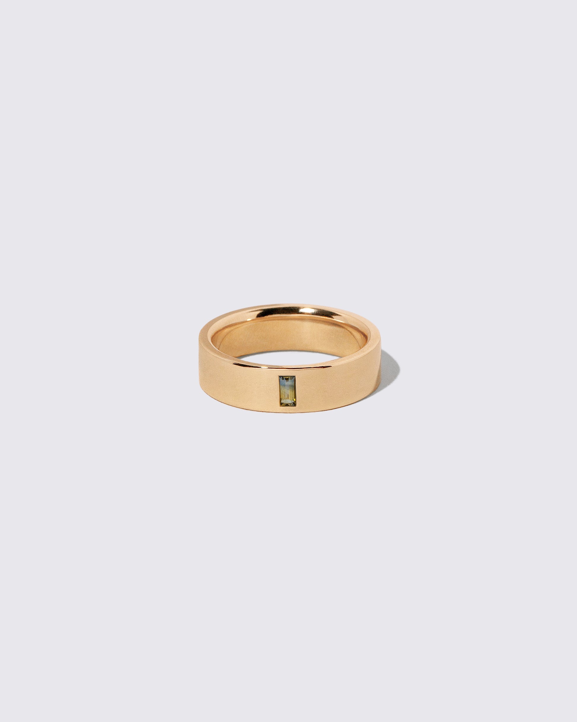 Gold Montana Bicolor Sapphire North South 6mm Baguette-Set Piet Band on light color background.