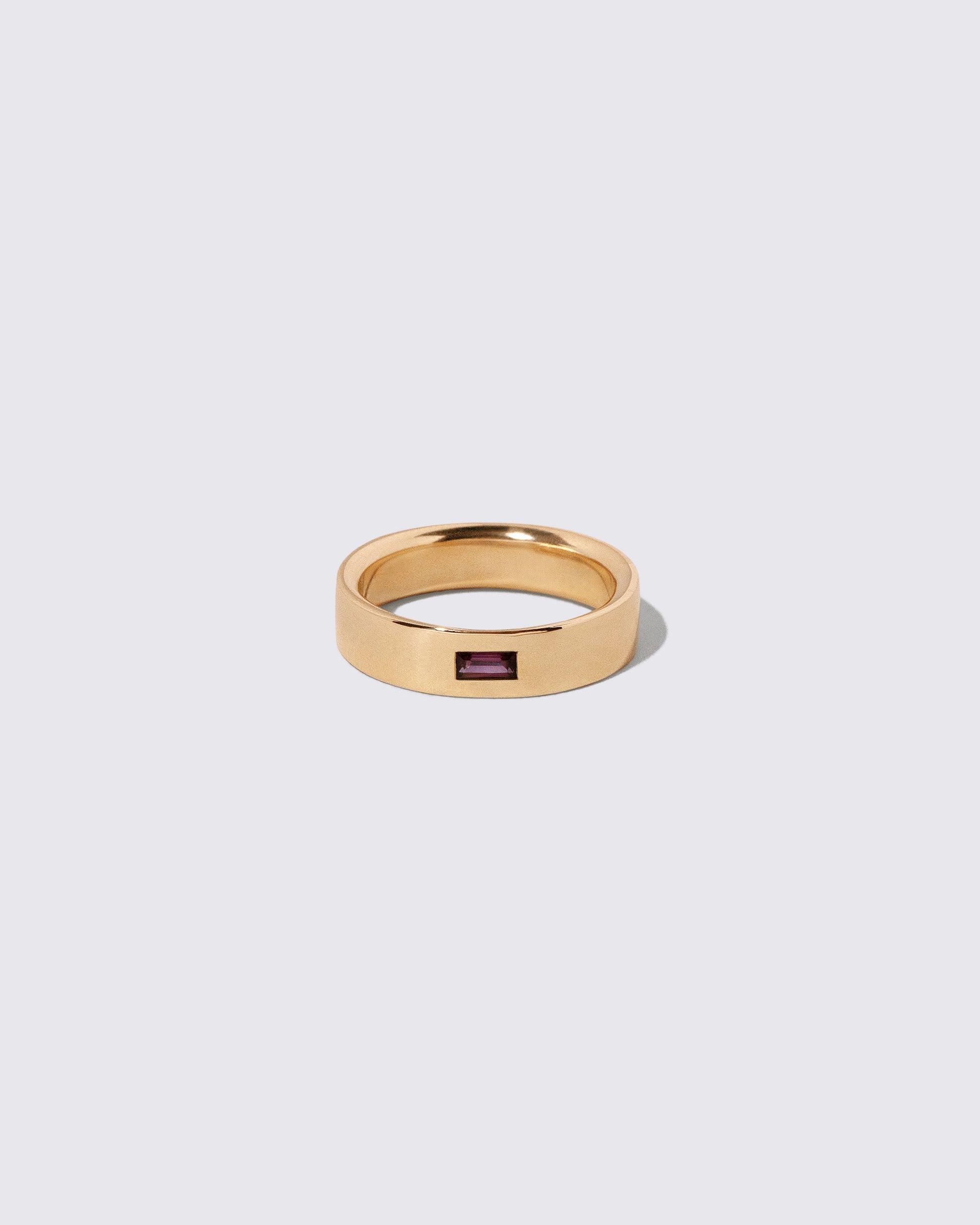 Gold Anthill Red Garnet East West 5mm Baguette-Set Piet Band on light color background.