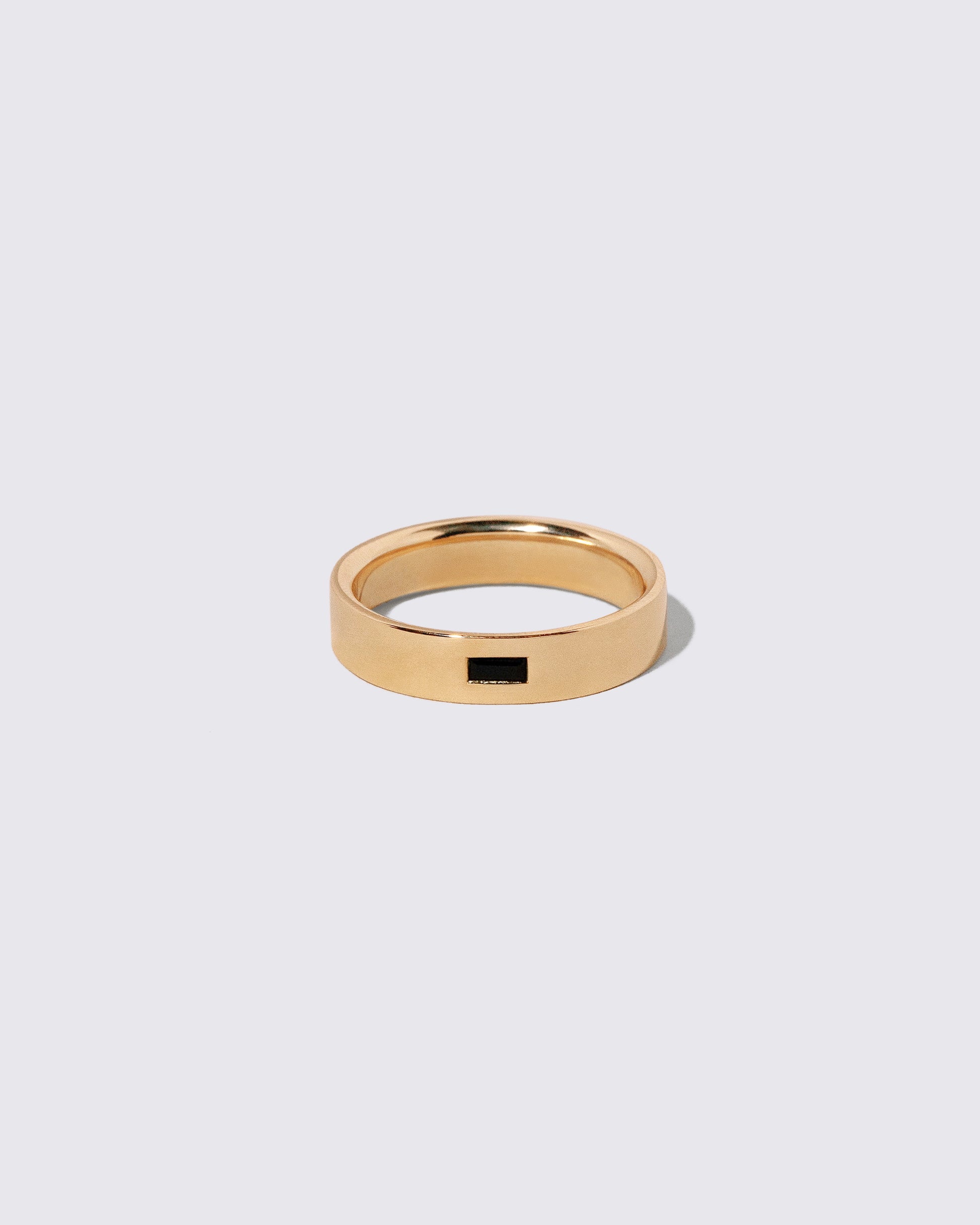 Gold Black Spinel East West 5mm Baguette-Set Piet Band on light color background.