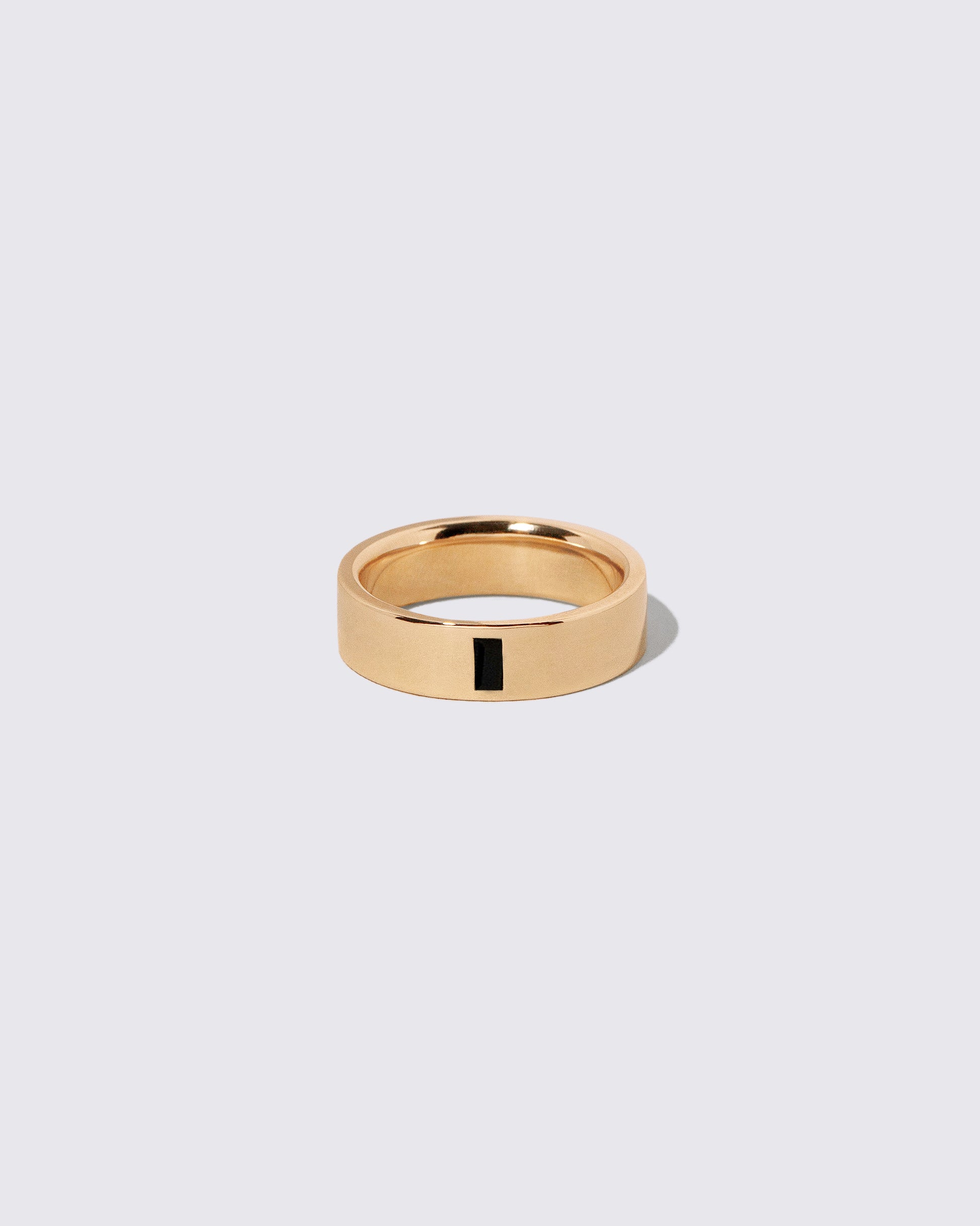 Gold Black Spinel North South 6mm Baguette-Set Piet Band on light color background.