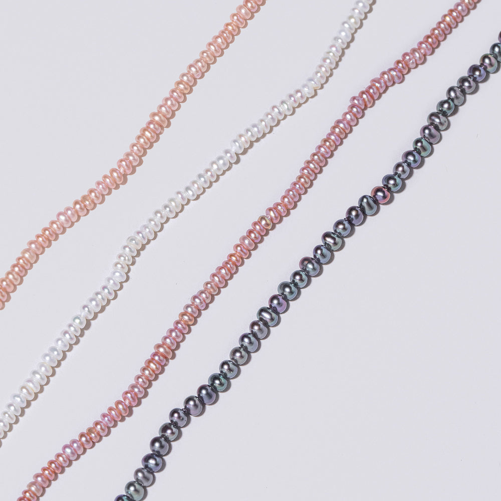 product_details::Closeup details of the Pink Peony Pebble Seed Pearl, White Seed  Pebble Pearl Bracelet, Pink Lavender  Pebble Seed Pearl Bracelet and Peacock  Pebble Seed Pearl Bracelet on light color background.
