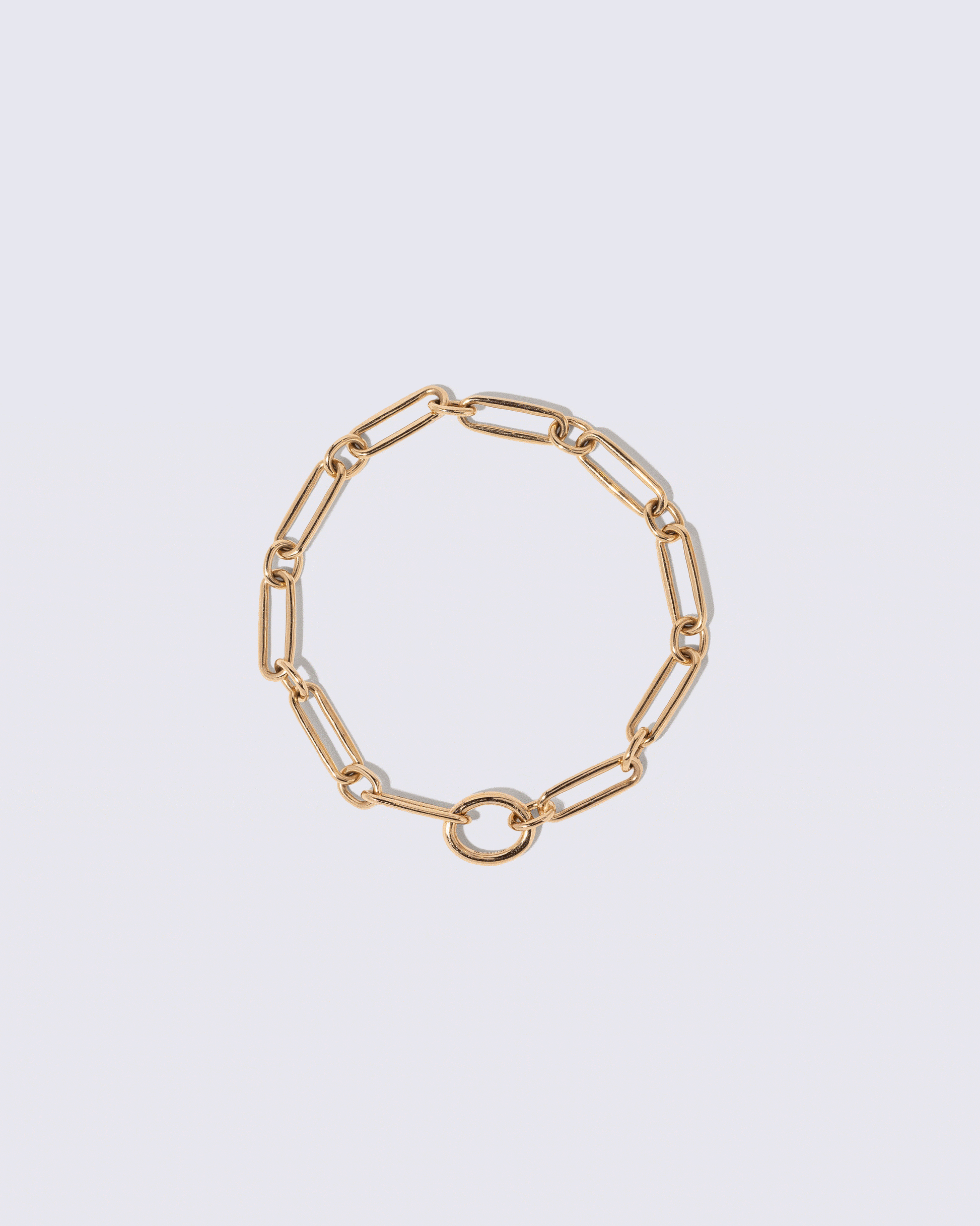 Animated detail view of the detachable Mociun Oval Openable Link closure on the Petite Link Bracelet and Blue Sapphire Gusher Charm on light color background.