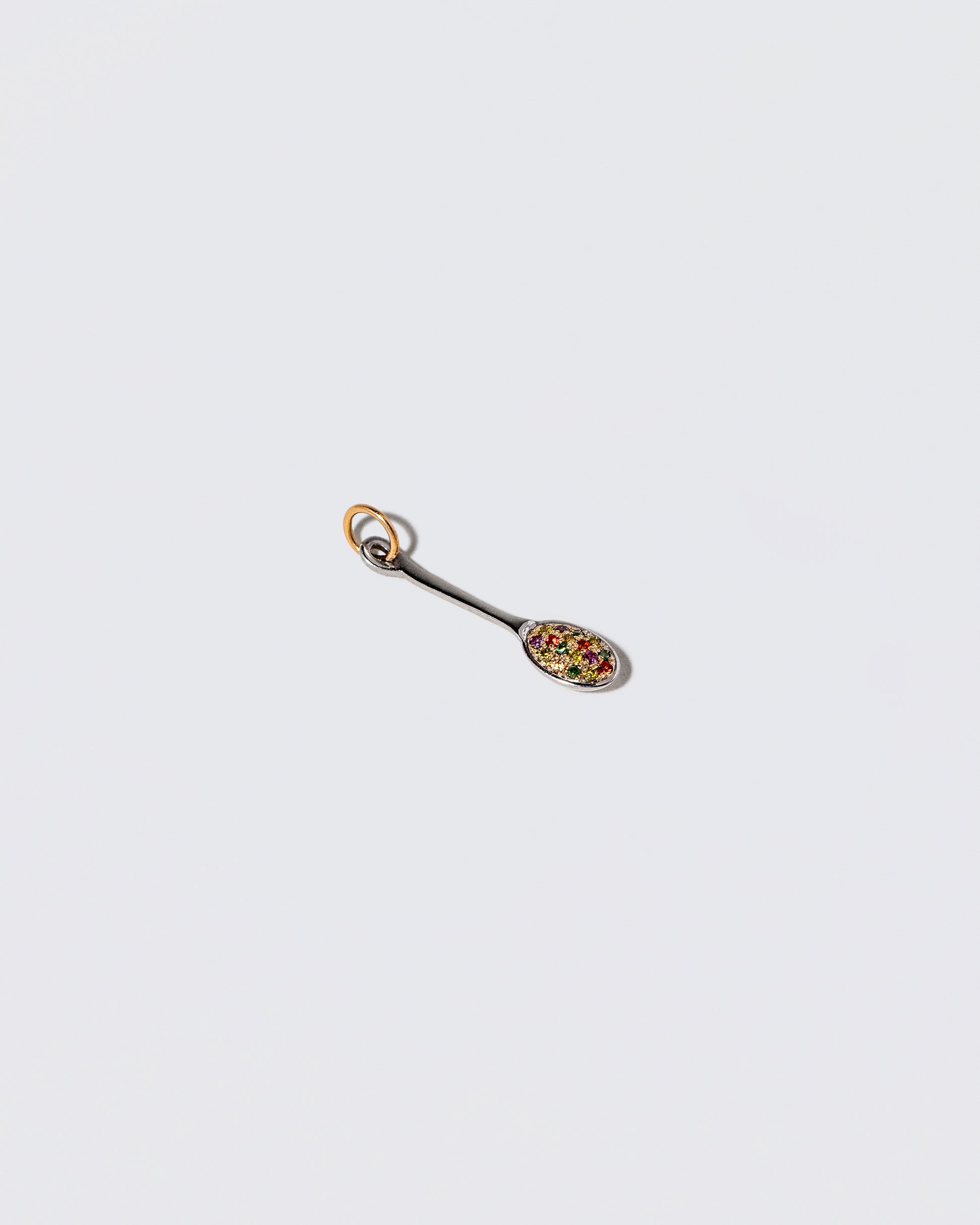 View from the side of the Cereal Spoon Charm on light color background.