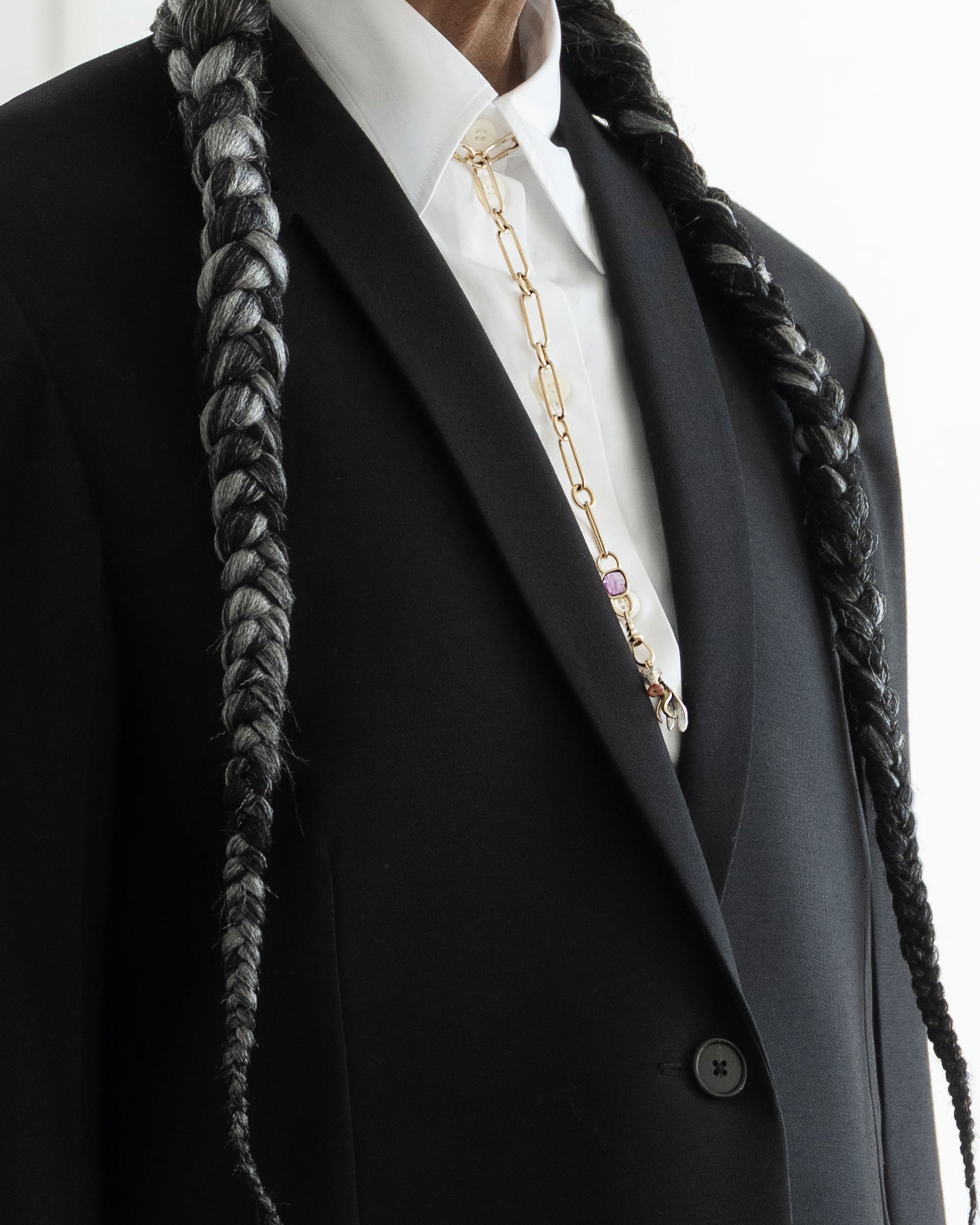Styled image on model featuring the Sapphire Gusher Openable Pendant connected to a closed-loop oval link of the Link Necklace worn as a lariat, and a Bruised Banana Peel Charm and Red Apple Core Charm suspended from its Gold Coiled Swivel Charm Holder clasp.