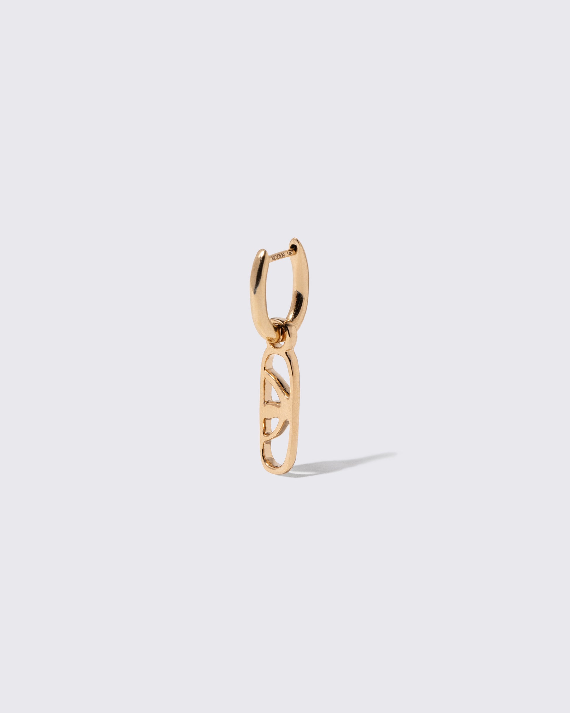 Closeup details of the Styling Huggie Hoop Earring Single and Cosmic Balance Styling Link on light color background. Earring sold separately.