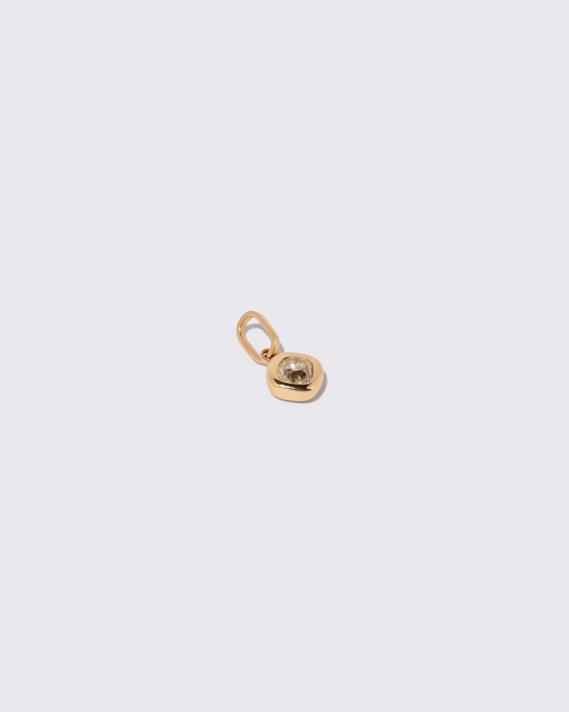 View from the side of the Diamond Poise Charm on light color background.