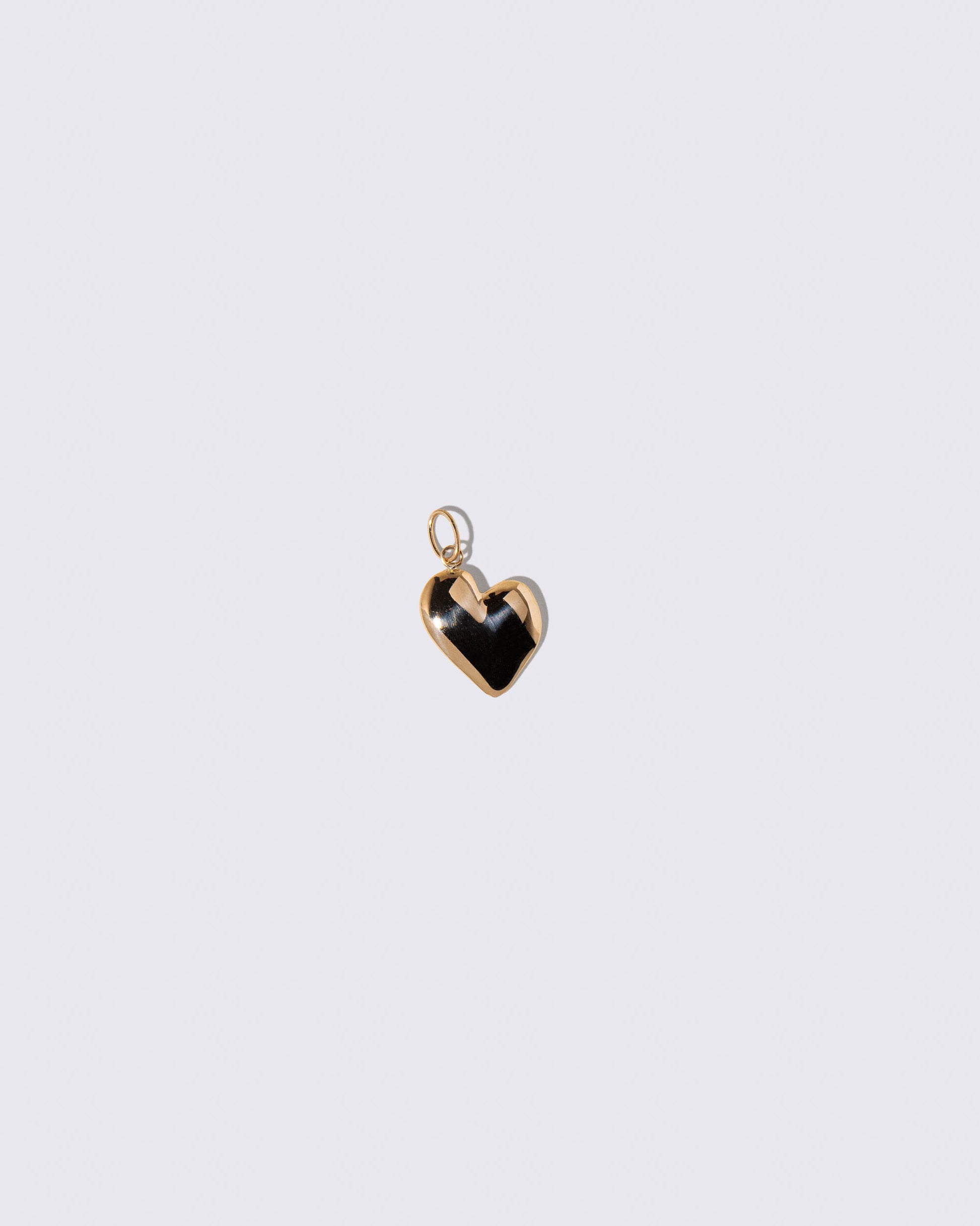 Gold Grand Thousand & One Night Heart Charm on light color background.