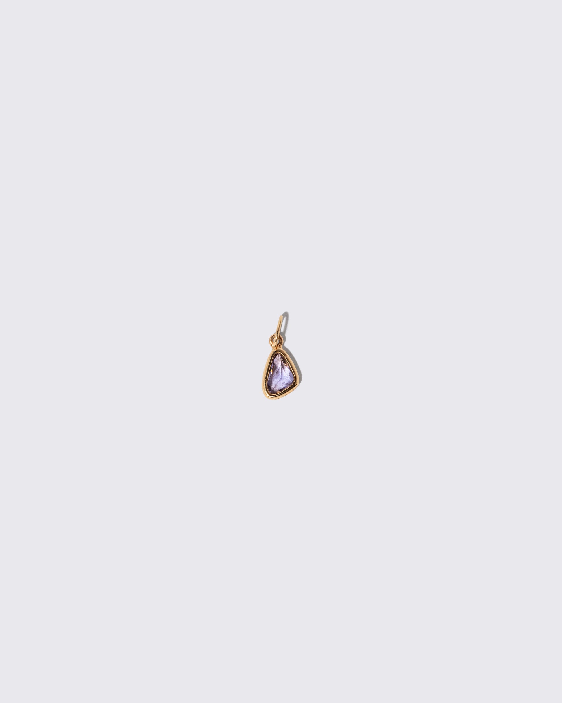 Blue Sapphire Gusher Charm on light color background.