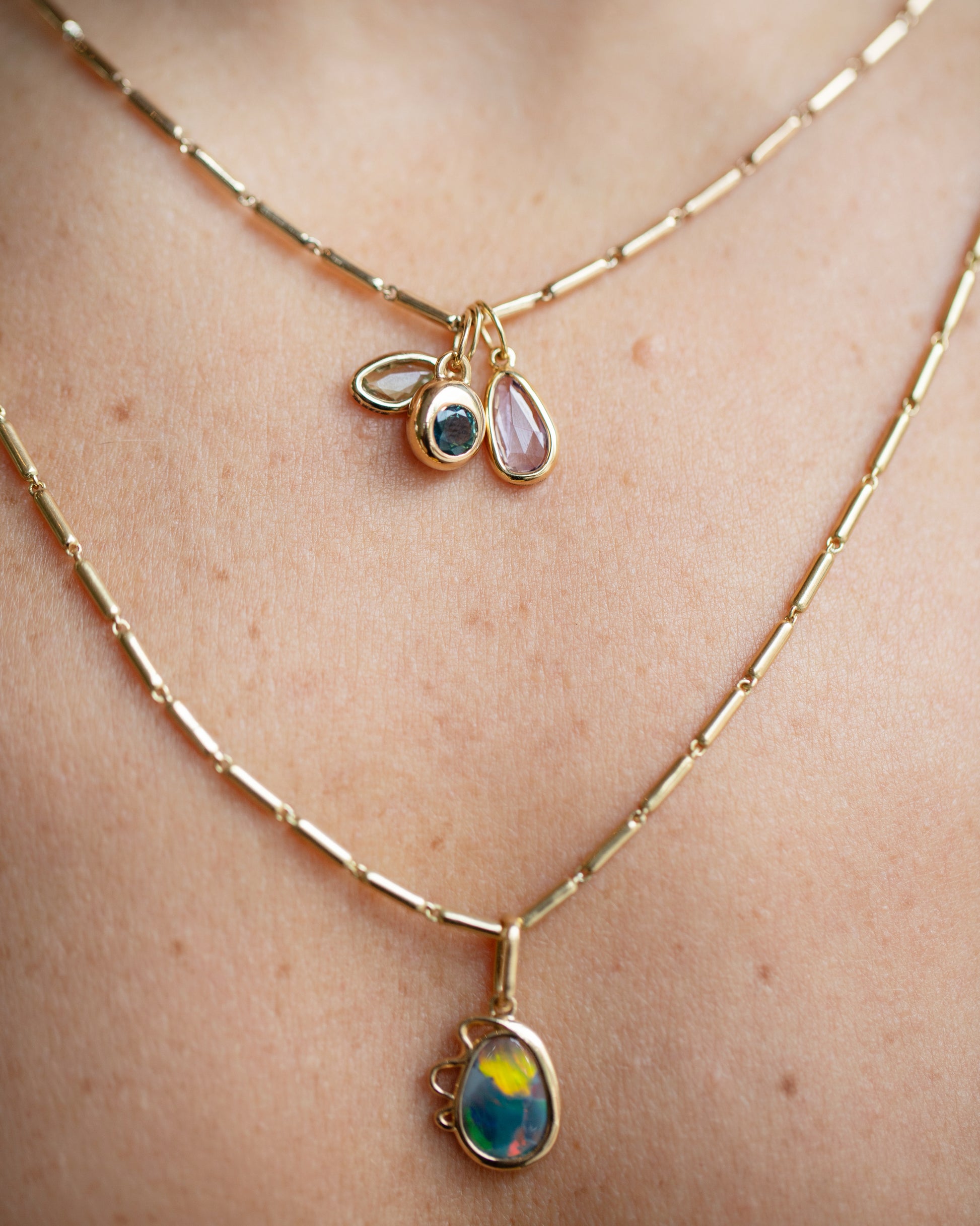 Harmony Pendant, Sapphire Birthstone Level Charm and Purple and Yellow Sapphire Gusher Charm with Gold Butter Chain Necklaces on model.