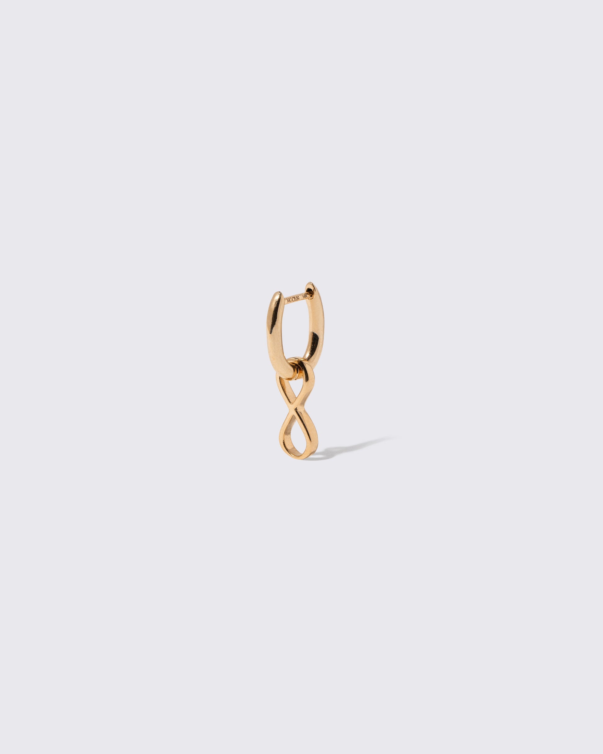 Closeup details of the Styling Huggie Hoop Earring Single and Infinity Styling Link on light color background. Earring sold separately.