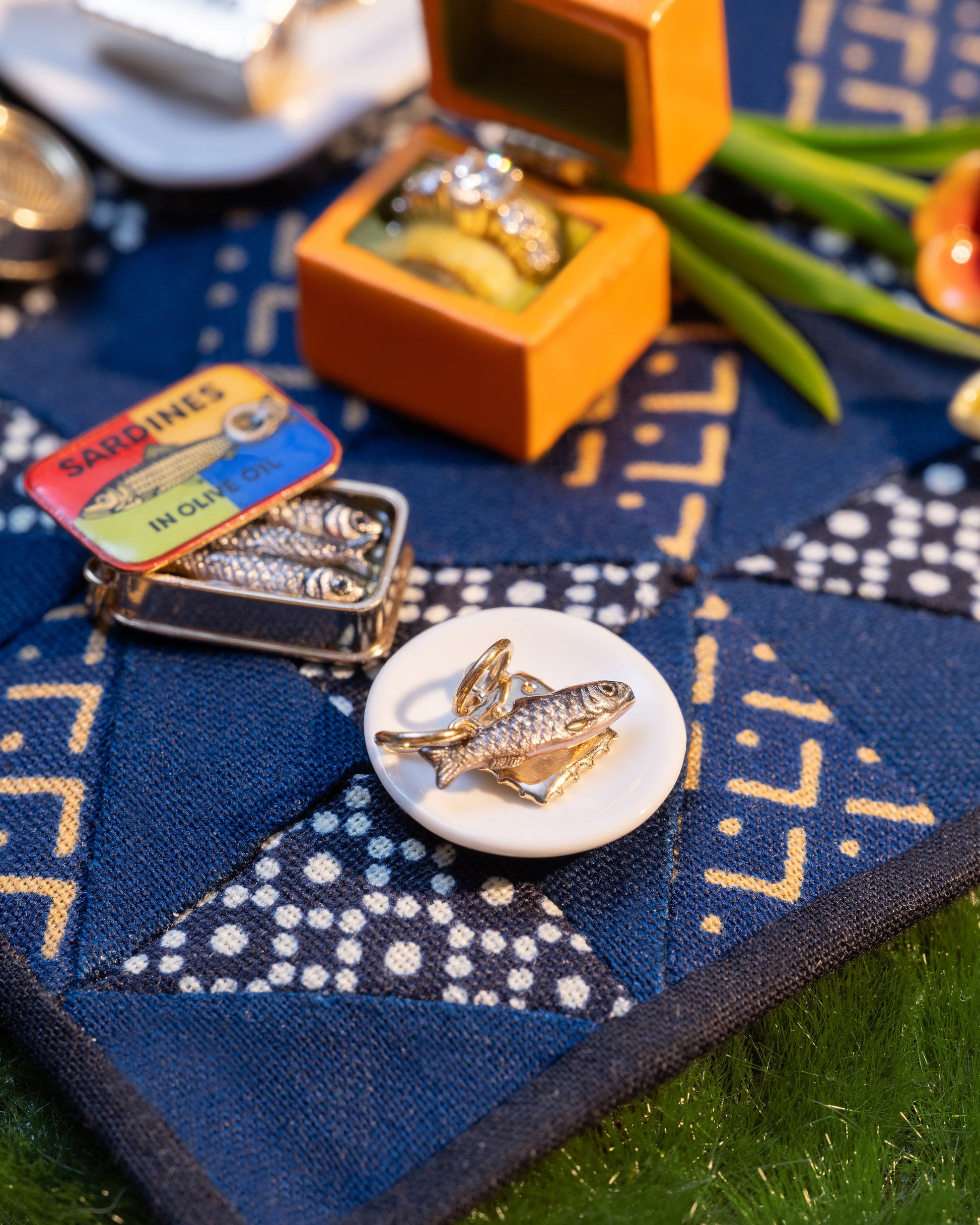 Styled image of the Sardine Charm, with Saltine Charm, Sardine Can Charm and Luna Ring Charm.