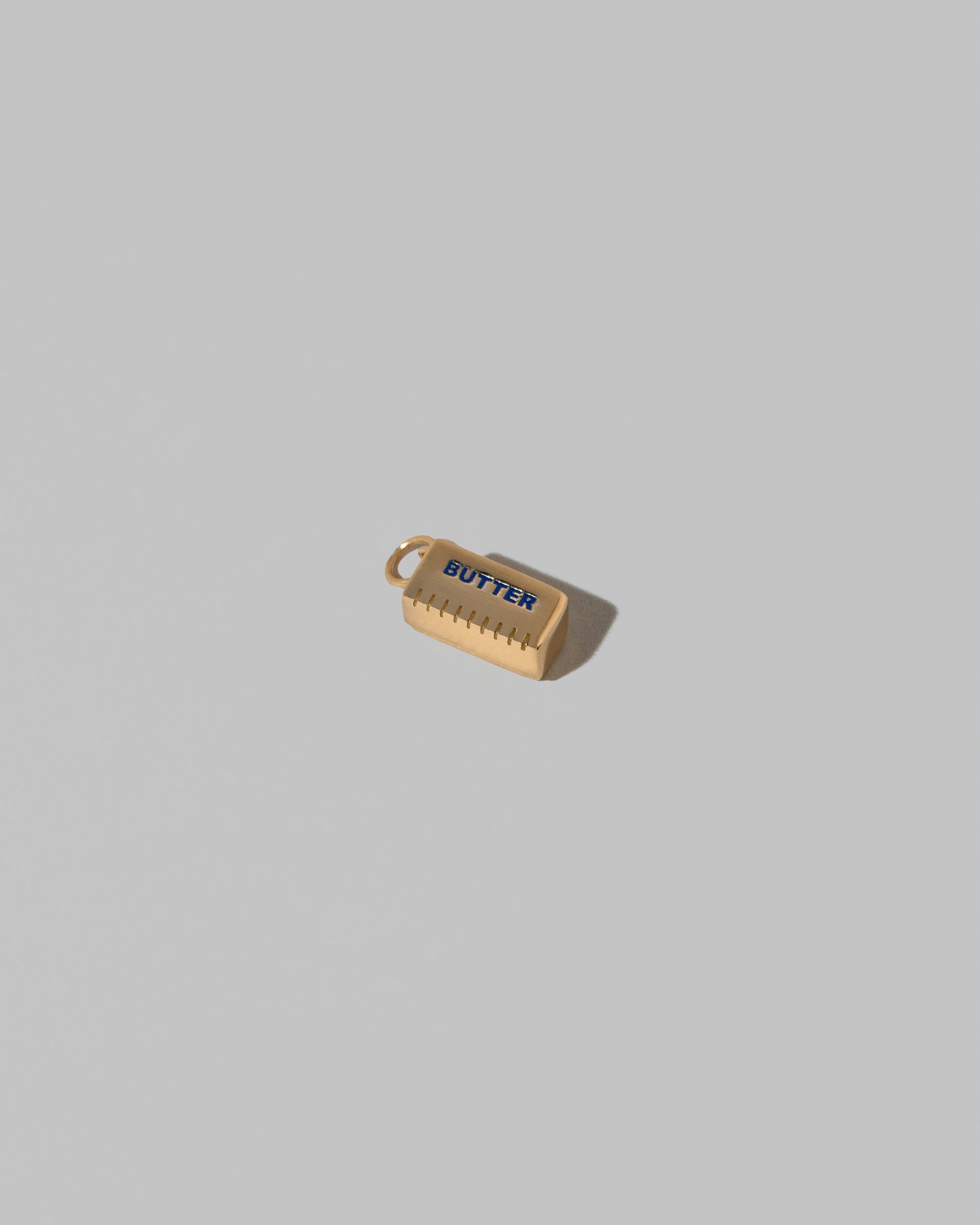Stick of Salted Butter Charm on light color background.