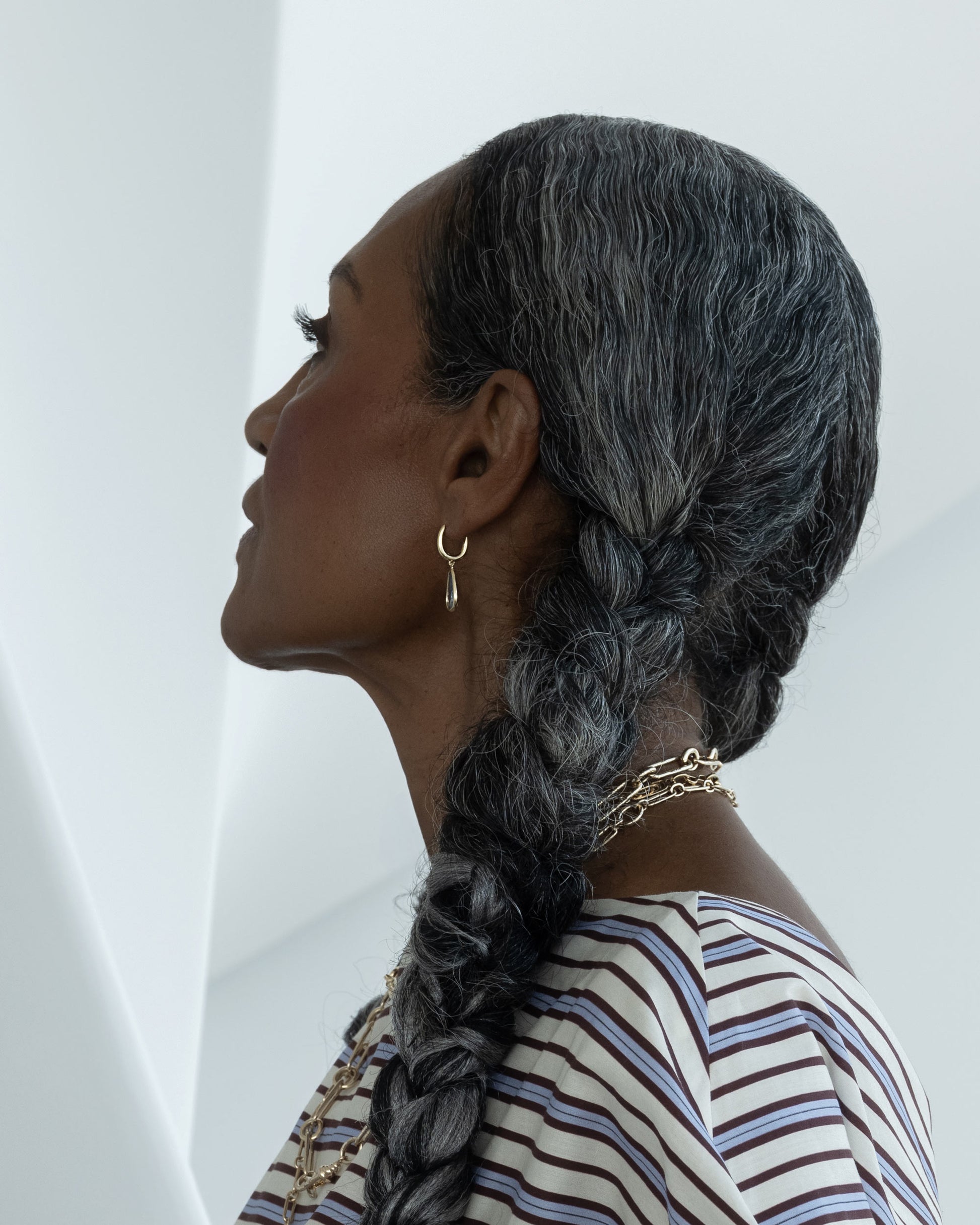 Styled image on model featuring the Blue Sapphire Gusher Charm Huggie Hoop Earrings and the Infinity Openable Link Necklace, Link Necklace and Petite Link Necklace.
