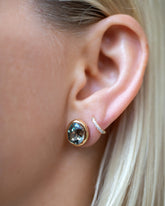 Juniper Stud Earrings styled with Huggie Gold Diamond Snack Hoop Earrings on model.