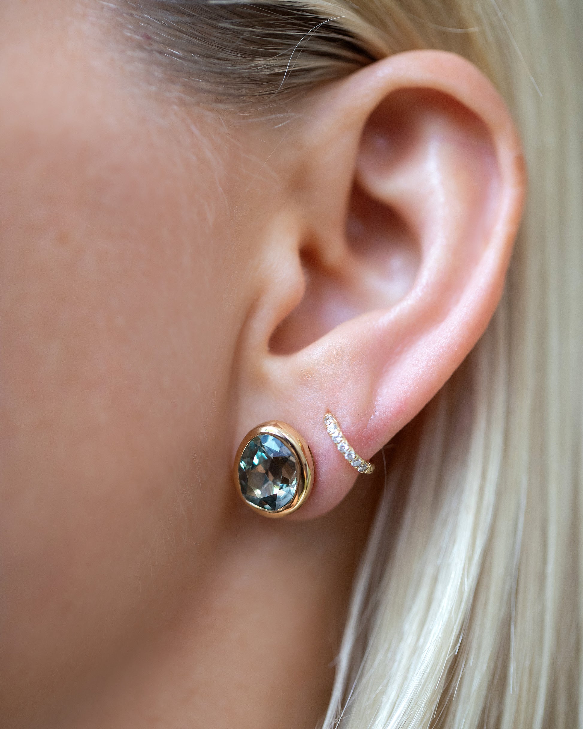 Juniper Stud Earrings styled with Huggie Gold Diamond Snack Hoop Earrings on model.