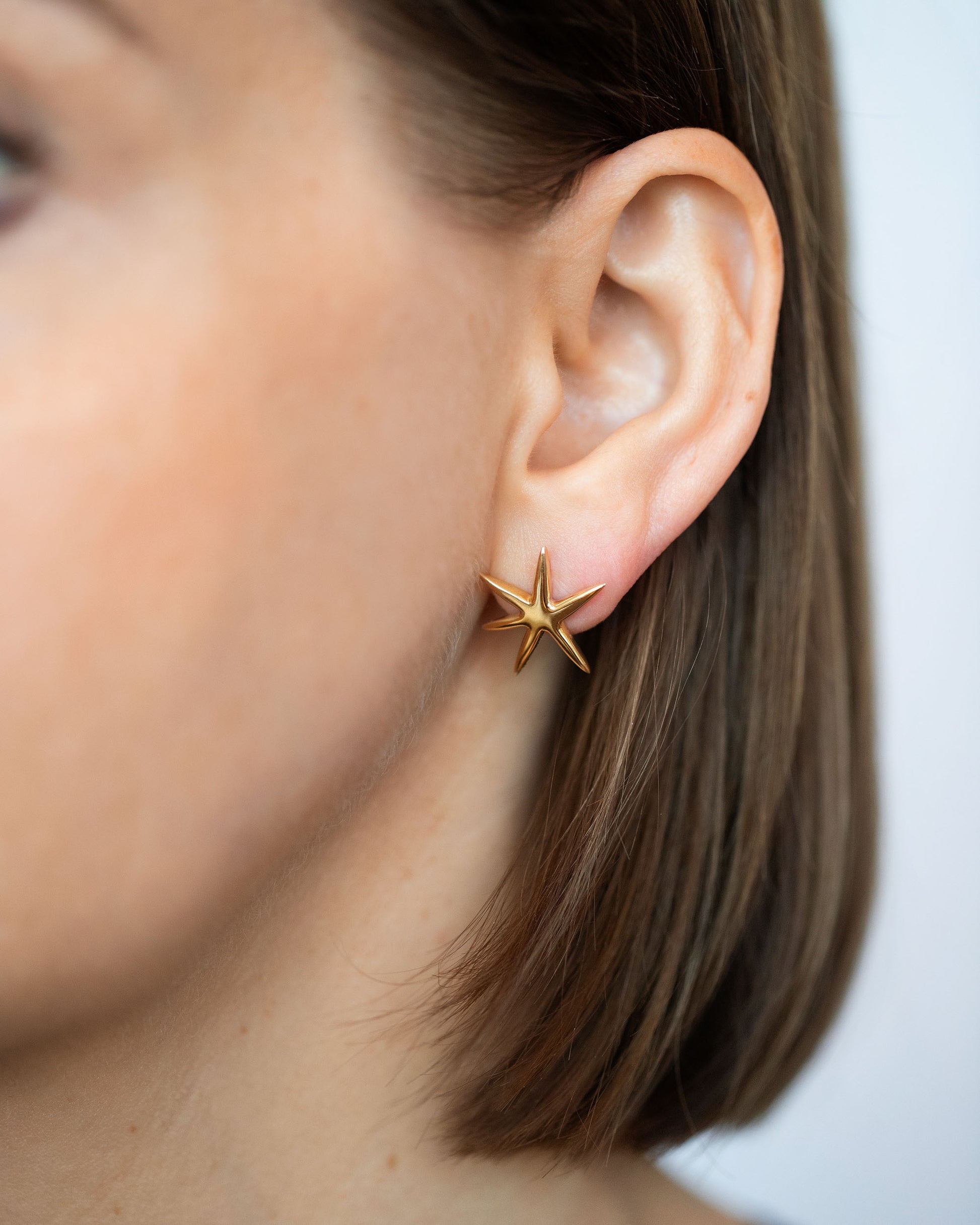 Gold Large Verve Six Point Star Stud Earrings on model.