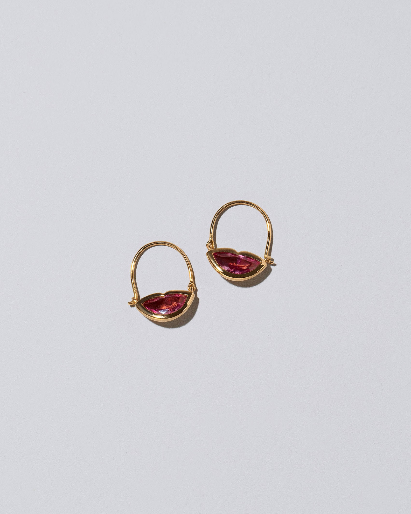 Closeup detail of the Bisous Hoop Earrings on light color background.
