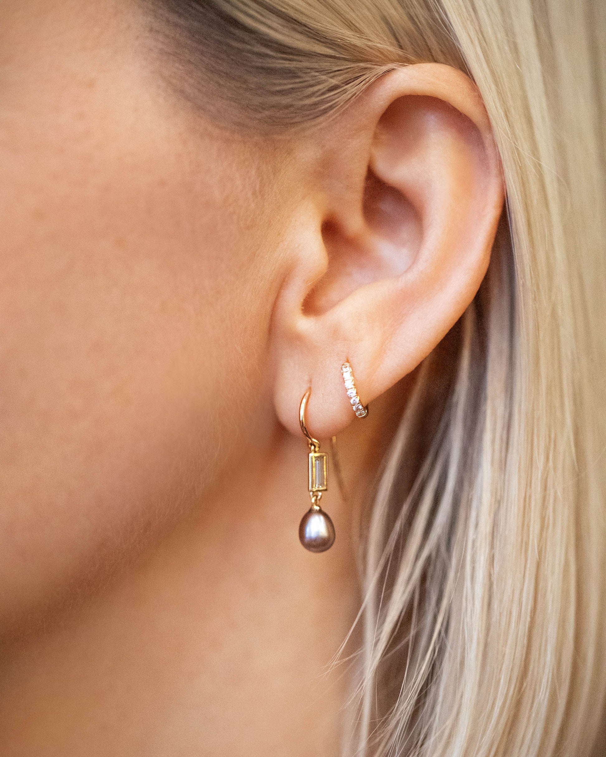 Poseidon Earrings and Huggie Gold Diamond Snack Hoop Earrings on model.