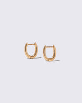 Closeup details of the Styling Huggie Hoop Earrings on light color background.