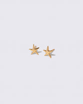 Gold Verve Five Point Star Stud Earrings on light color background.
