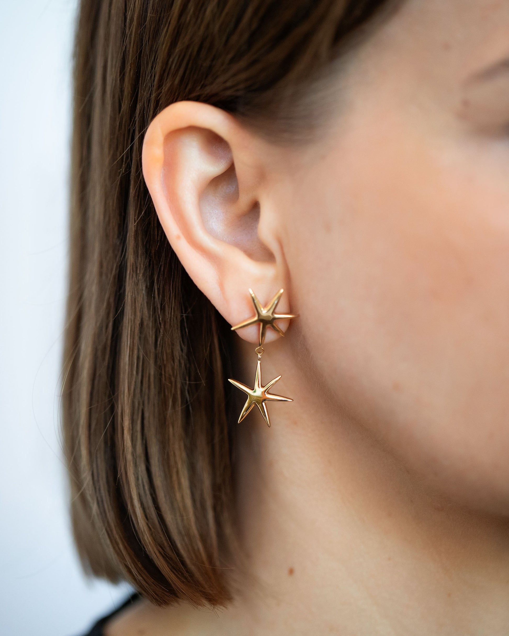 Gold Verve Star Drop Earrings on model.
