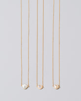 Group of the White Lagniappe Pearl Necklaces on light color background.