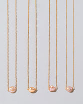Group of Blush Pink Lagniappe Pearl Necklaces on light color background.
