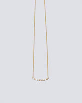 Opal Crescent Necklace on light color background.
