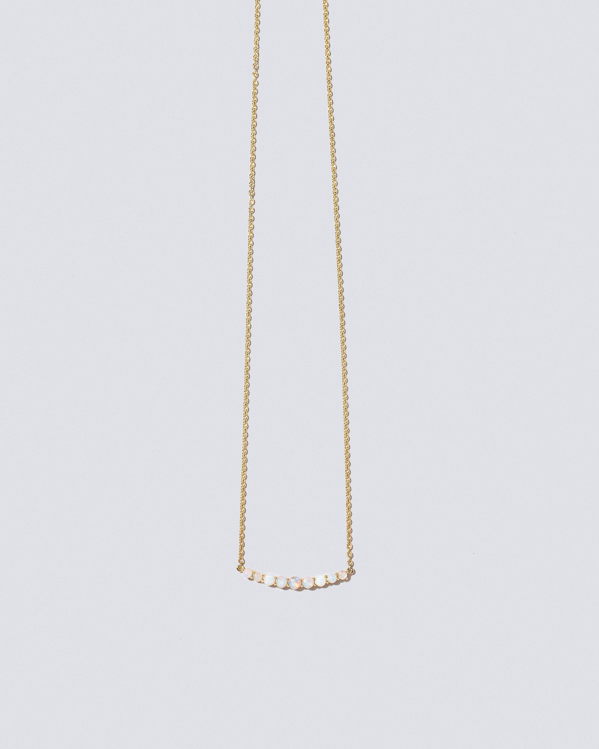 Opal Crescent Necklace on light color background.
