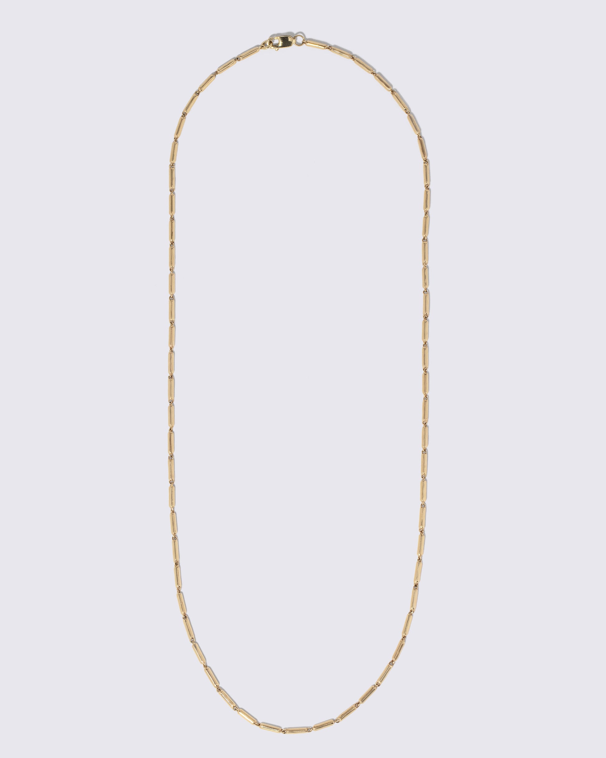 Gold Butter Chain Necklace on light color background.