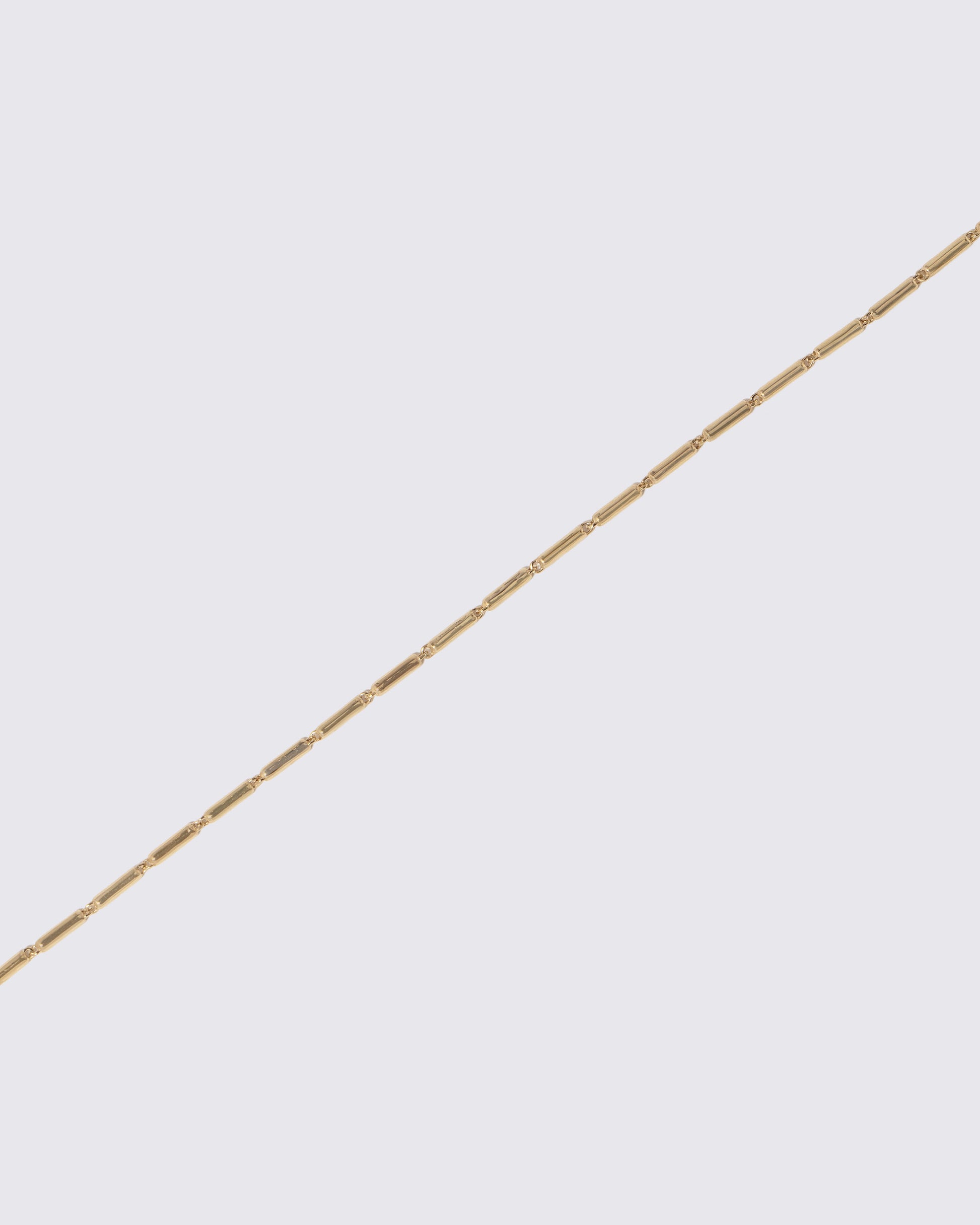 Closeup details of the Gold Butter Chain Necklace on light color background.