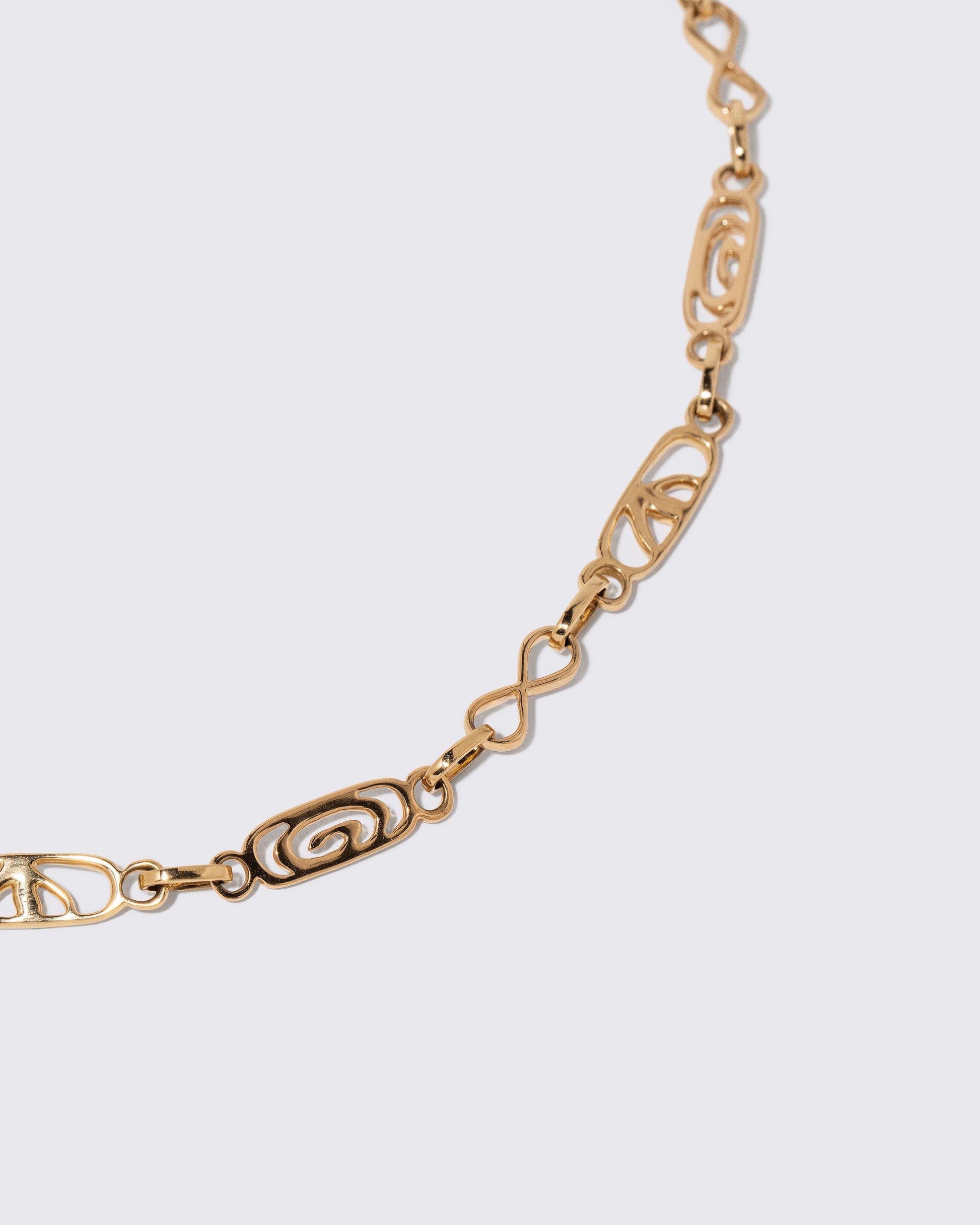 Closeup details of the Infinity Openable Link Necklace on light color background.