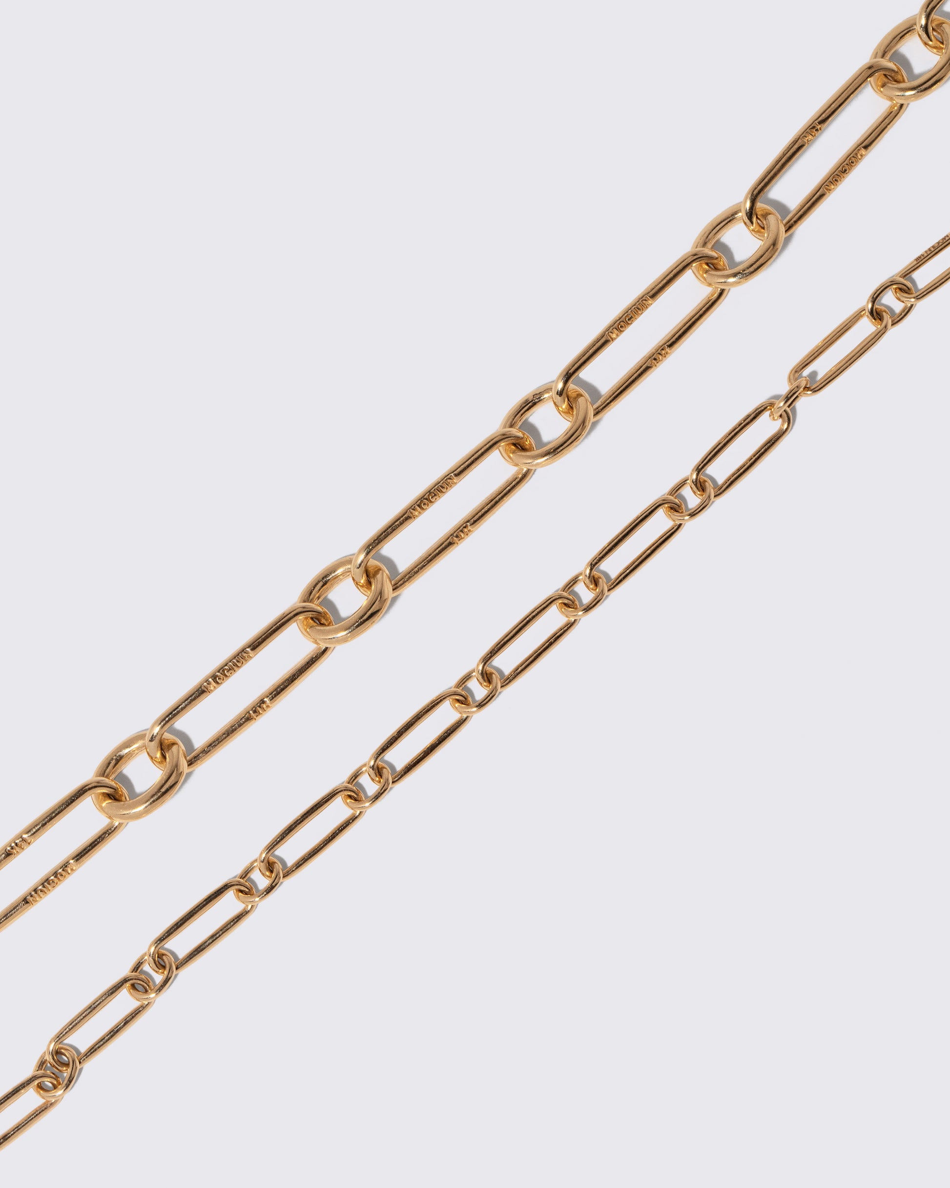 Closeup details of the Link Necklace and Petite Link Necklace on light color background.