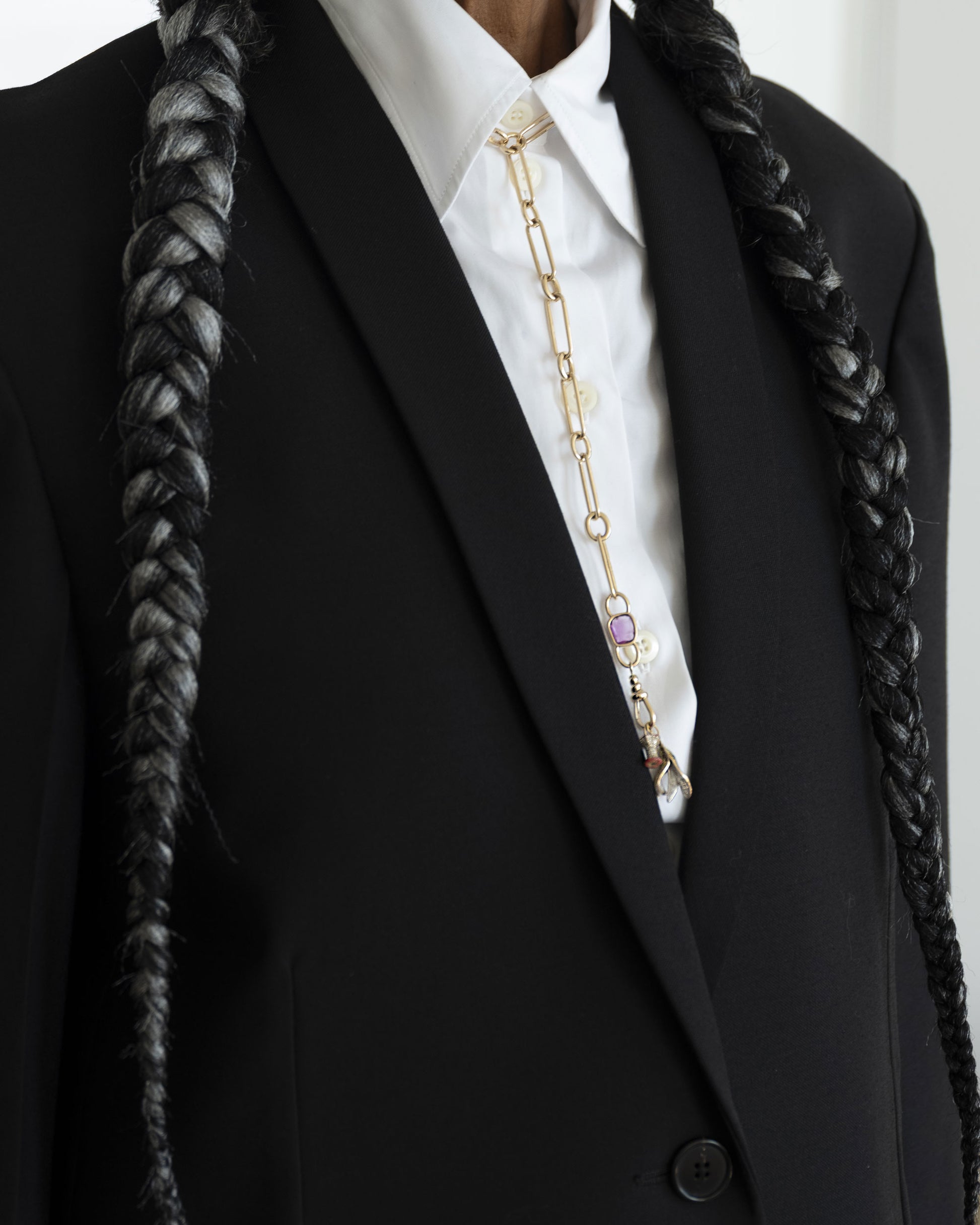 Styled image on model featuring the Sapphire Gusher Openable Pendant connected to a closed-loop oval link of the Link Necklace worn as a lariat, and a Bruised Banana Peel Charm and Red Apple Core Charm suspended from its Gold Coiled Swivel Charm Holder clasp.