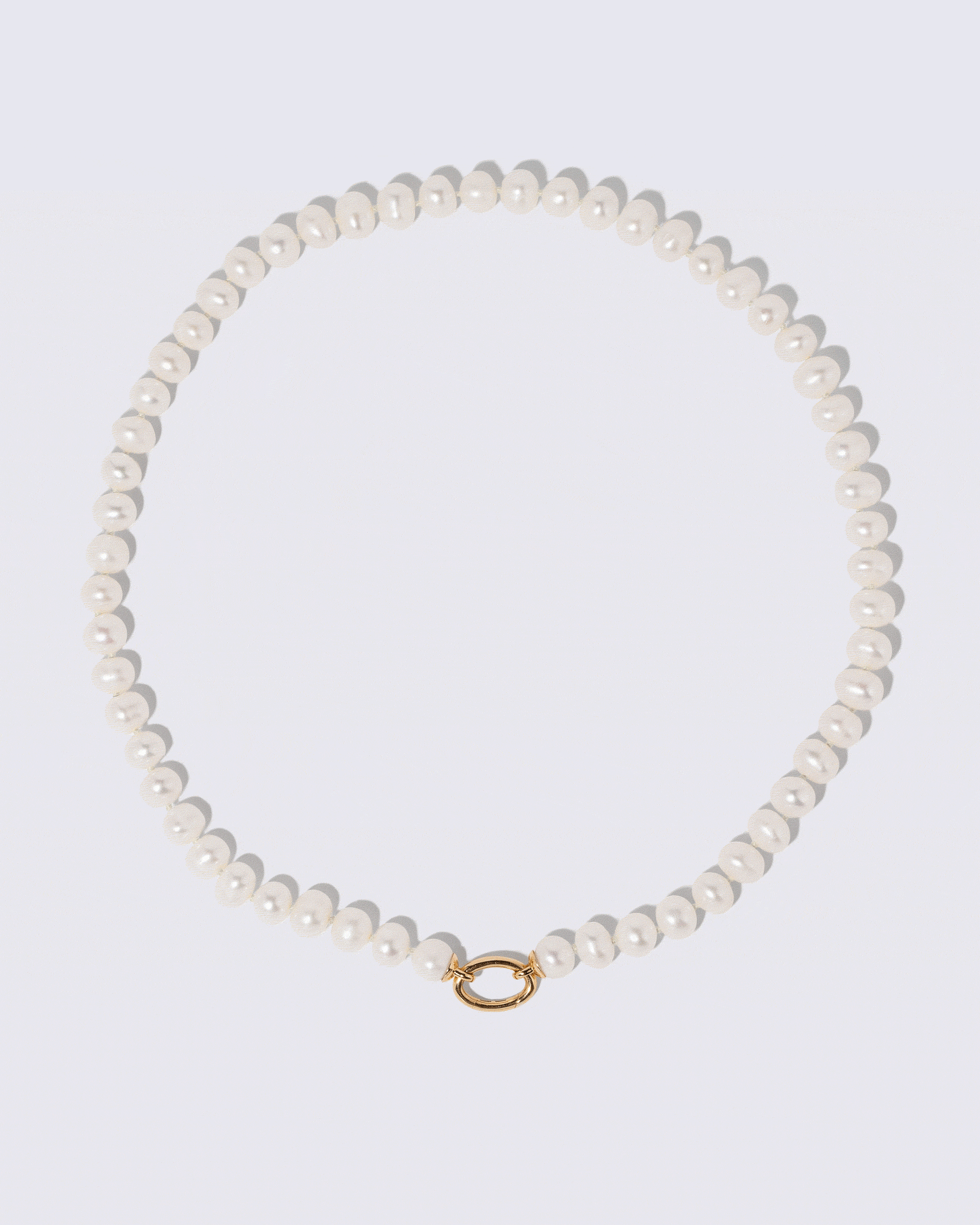 Animated detail view of the detachable Mociun Long Oval Openable Link closure on the Gold Pearl Openable Link Necklace and Diamond Poise Charm on light color background.