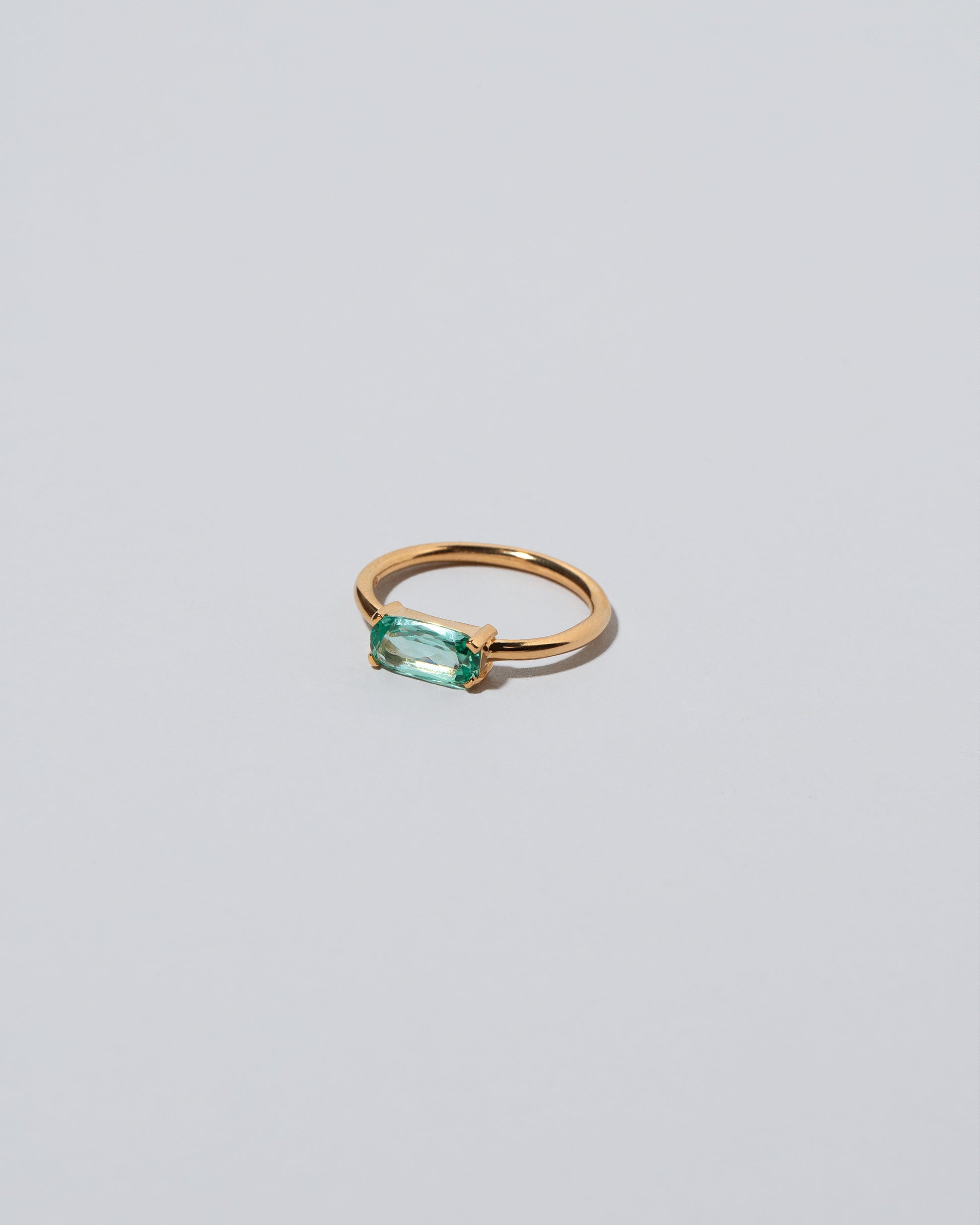 View from the side of the Green Adage Ring on light color background.