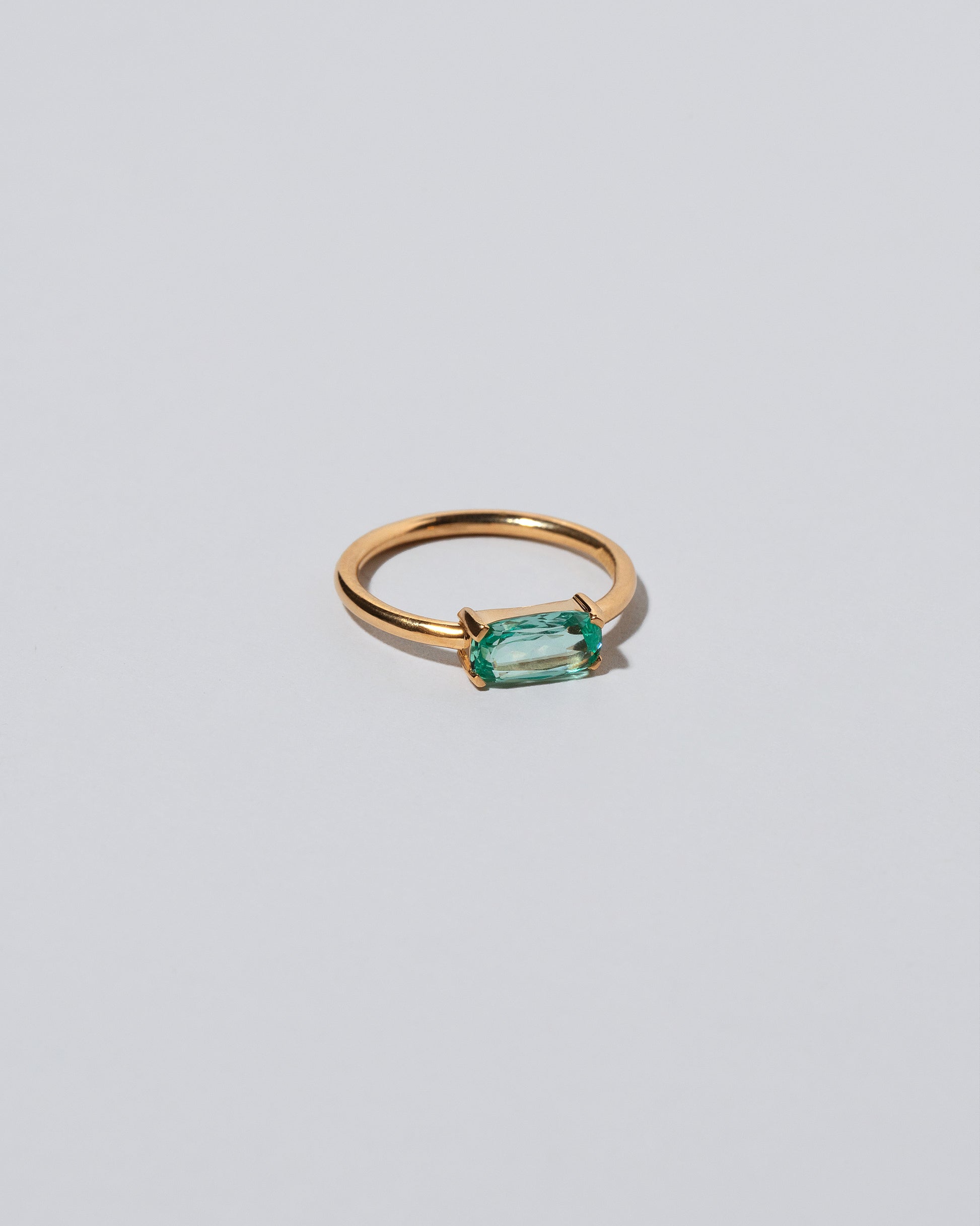 View from the side of the Green Adage Ring on light color background.