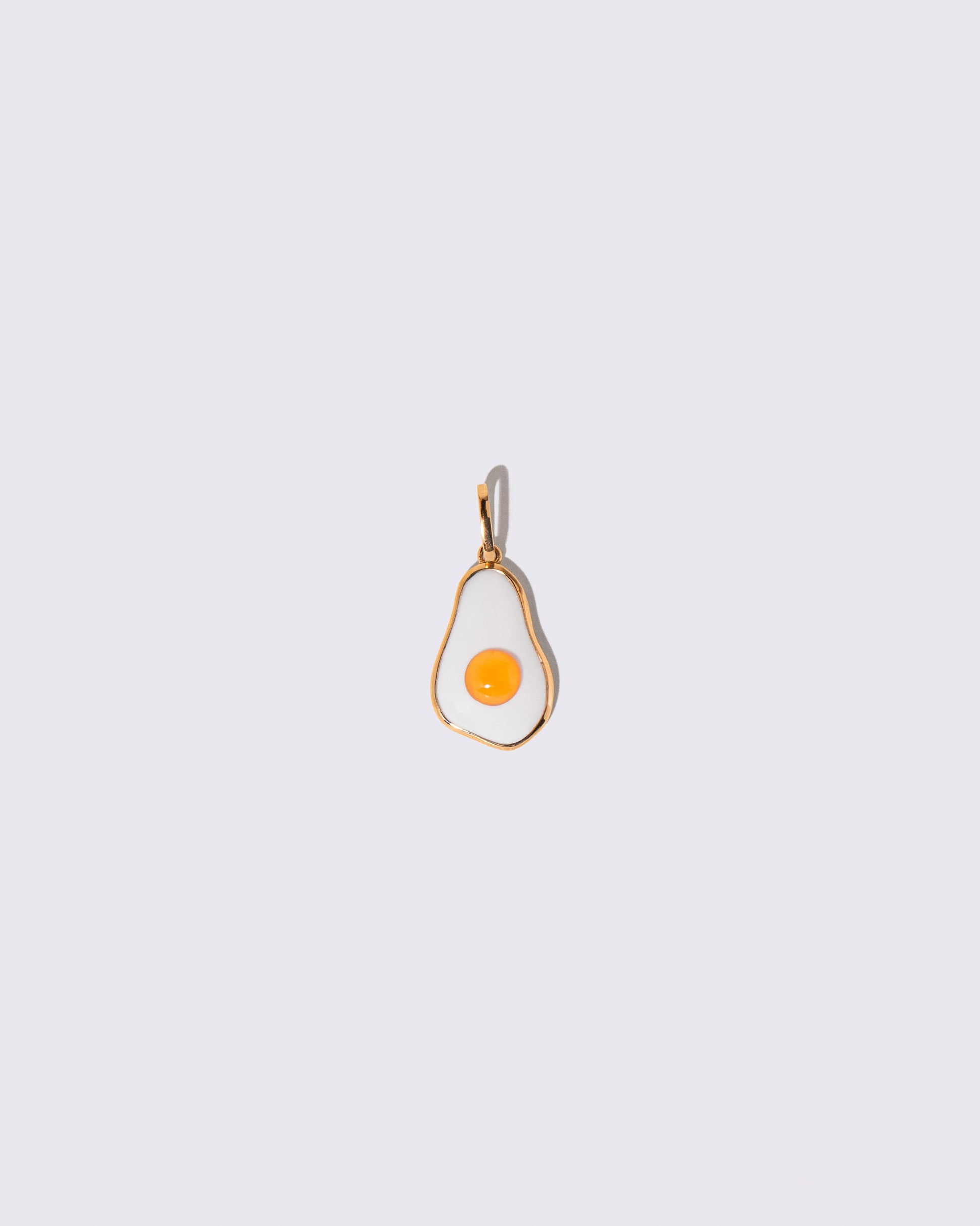 Fried Egg Pendant on light color background.