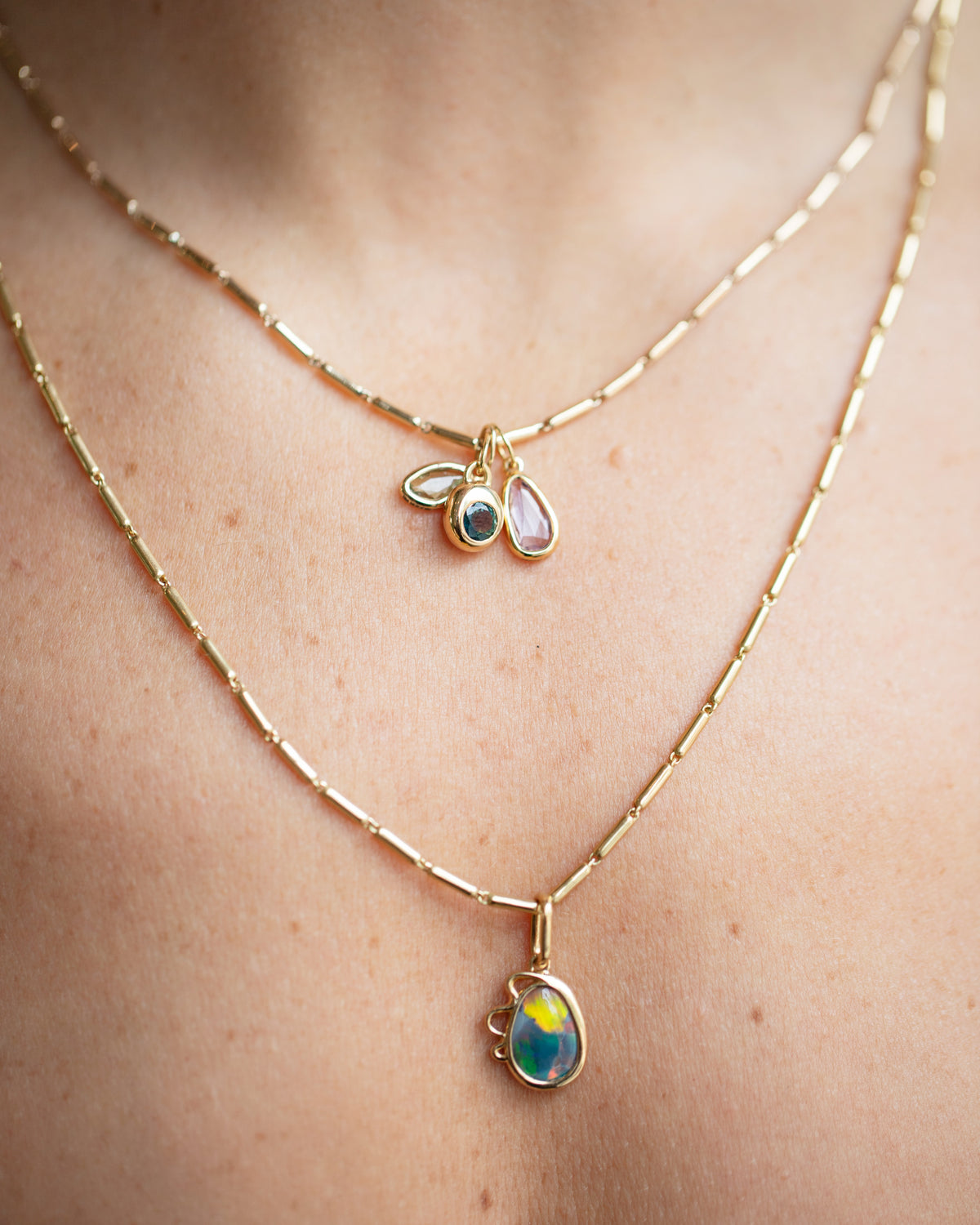 Harmony Pendant, Sapphire Birthstone Level Charm and Purple and Yellow Sapphire Gusher Charm with Gold Butter Chain Necklaces on model.