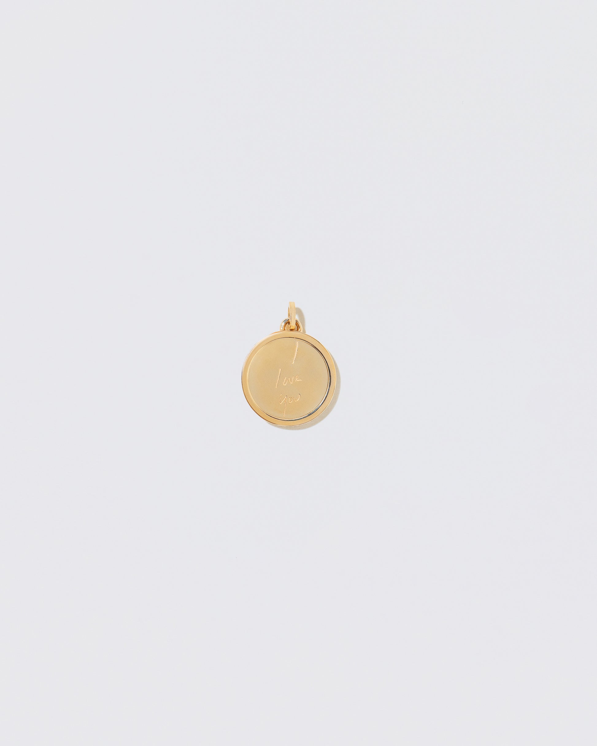 View from the back of a finished Small Round Pendant Memento Pendant engraved with 'I Love You' on light color background.