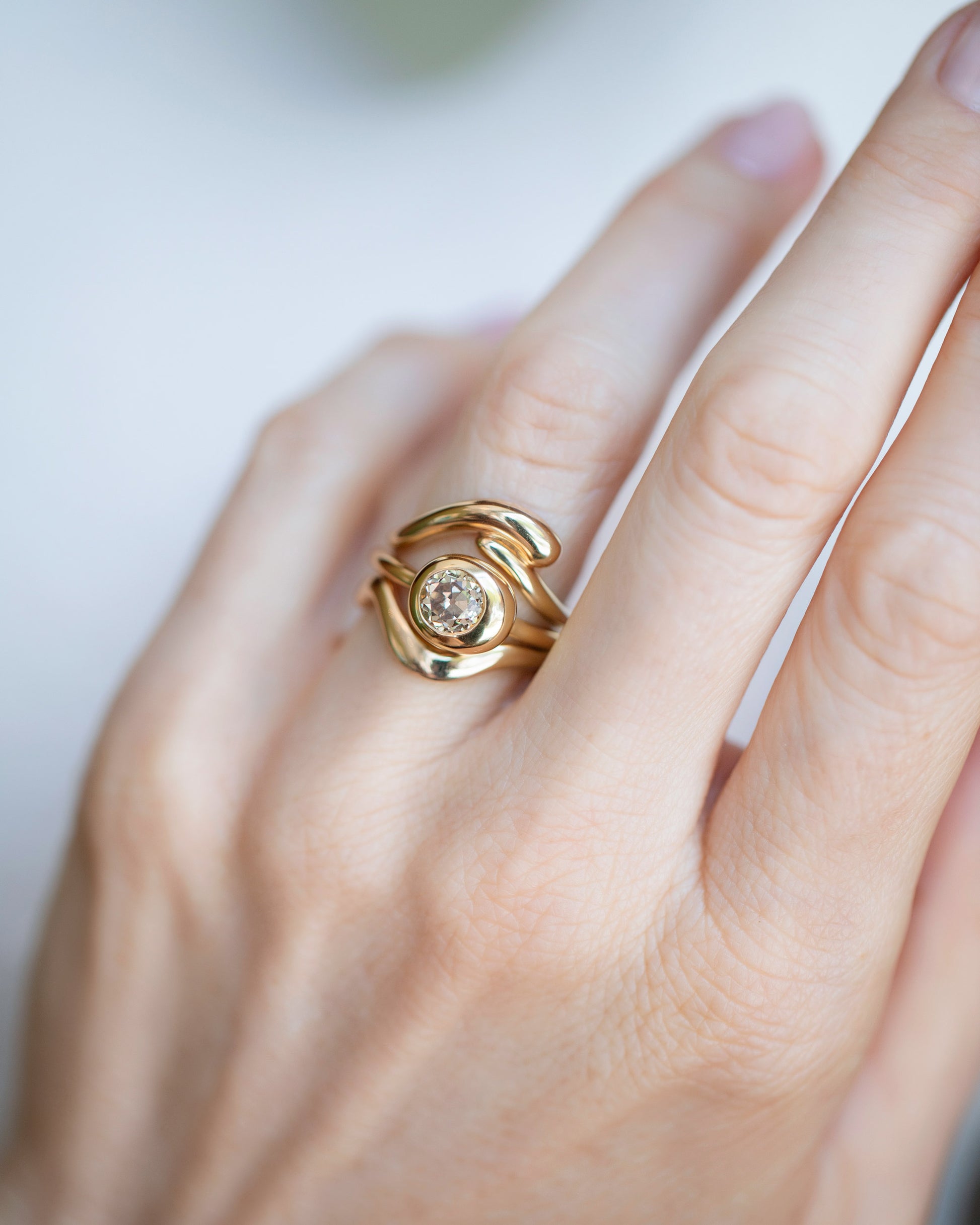 Diamond Level Ring, Gold Align Band and Gold Thin Planate Band stack on model.