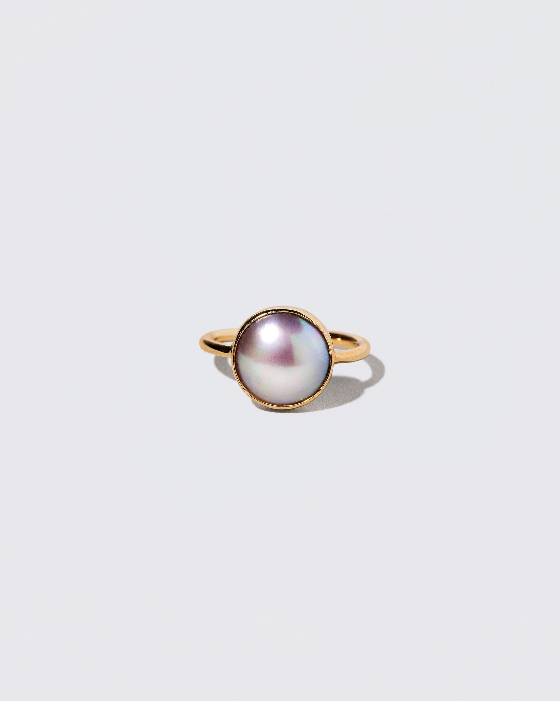 Gold Albert Ring on light color background.