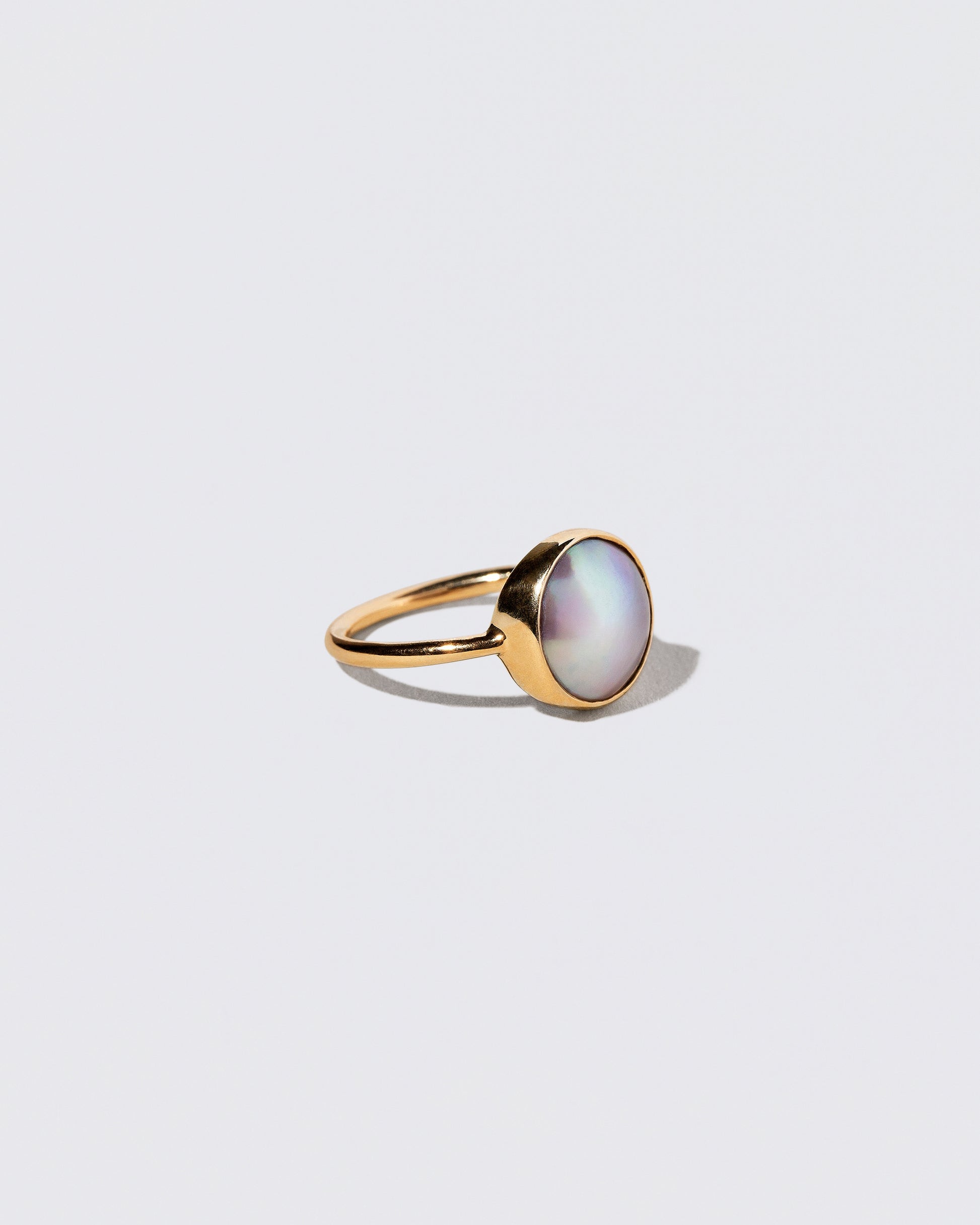 View from the side of the Gold Albert Ring on light color background.
